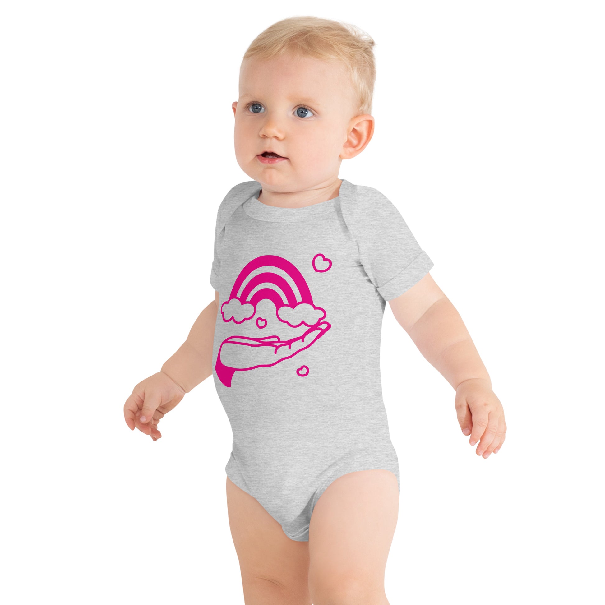 baby with grey short sleeve one piece with print of pink hand holding a pink rainbow
