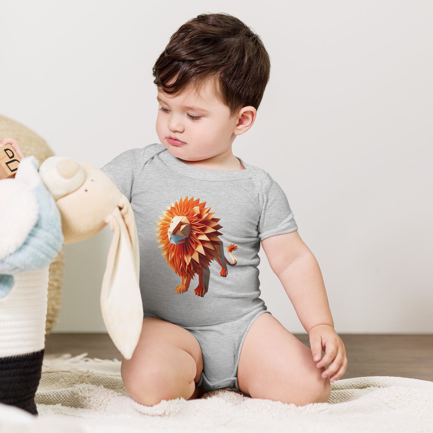 Baby with grey bodysuit with print of a lion