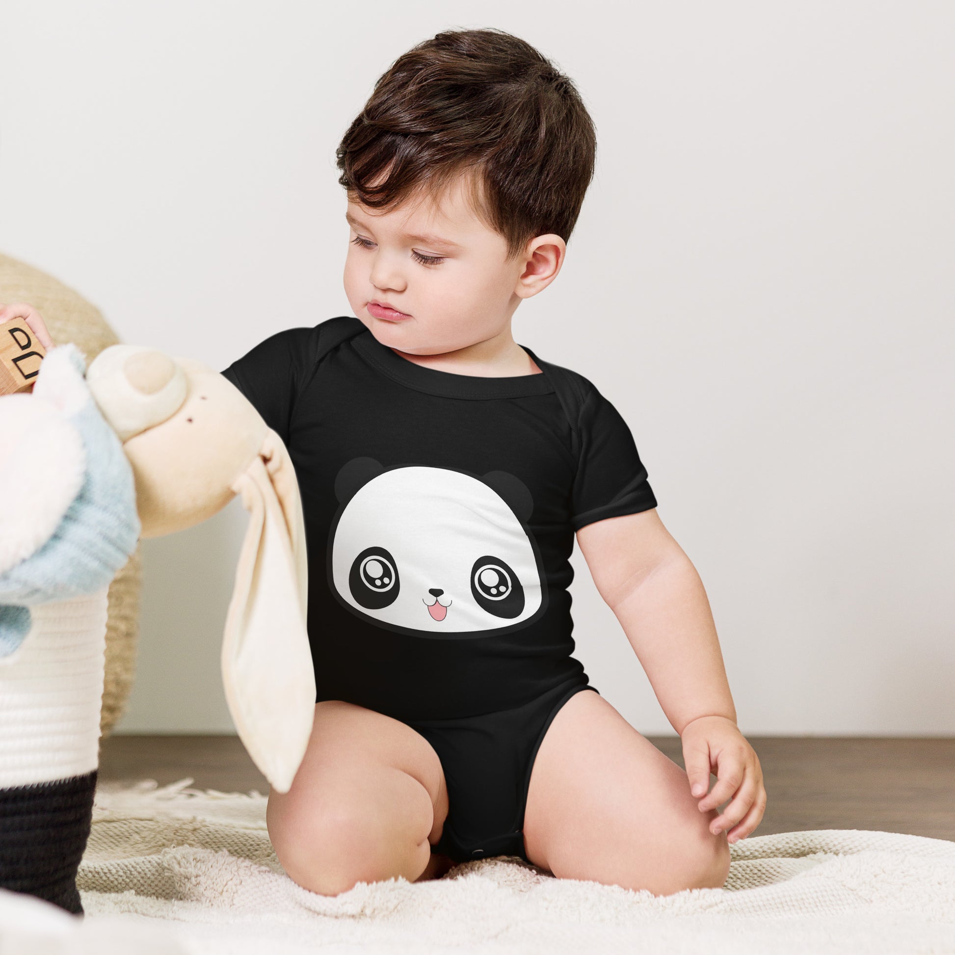 Baby with black babysuit with print of panda head