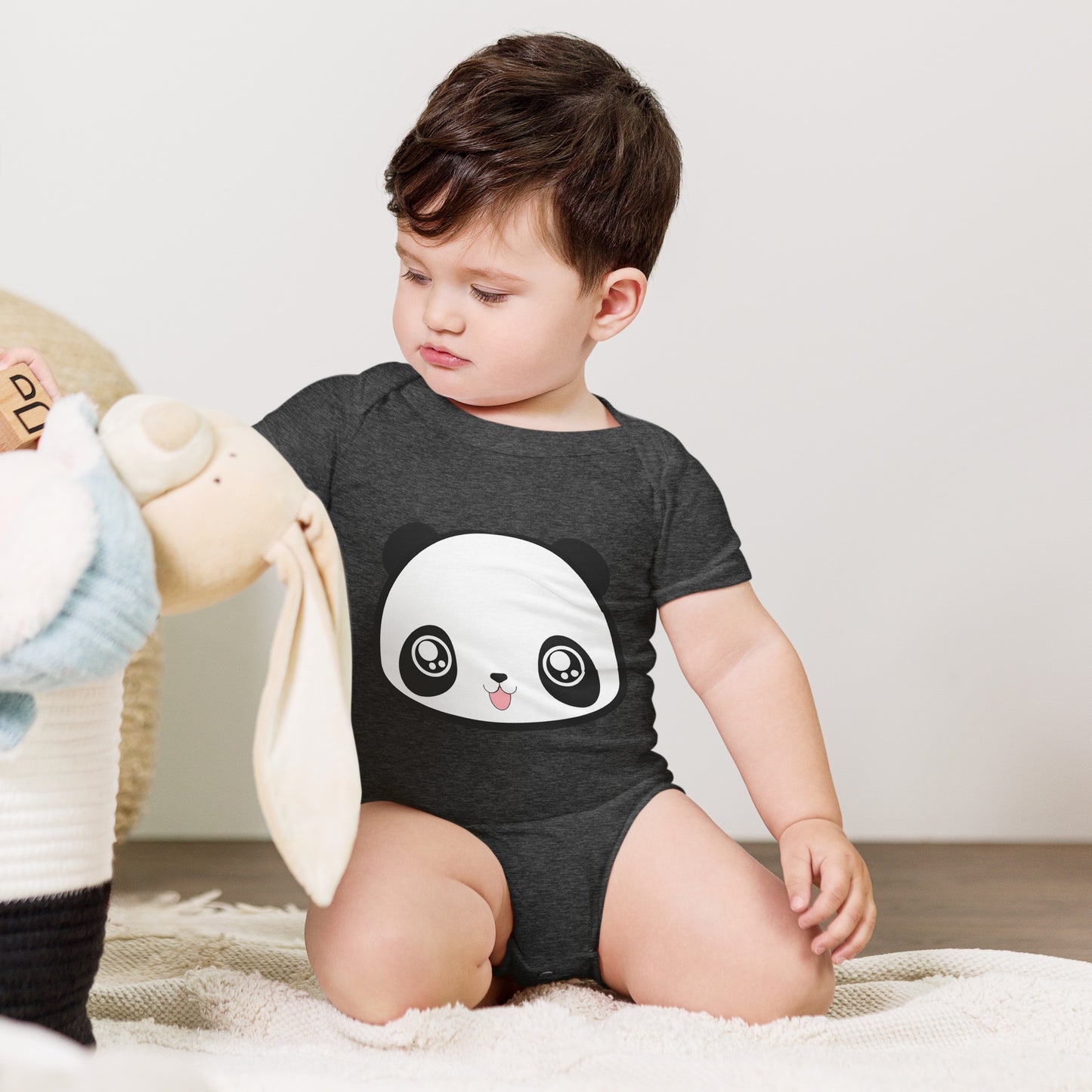 Baby with dark grey babysuit with print of panda head