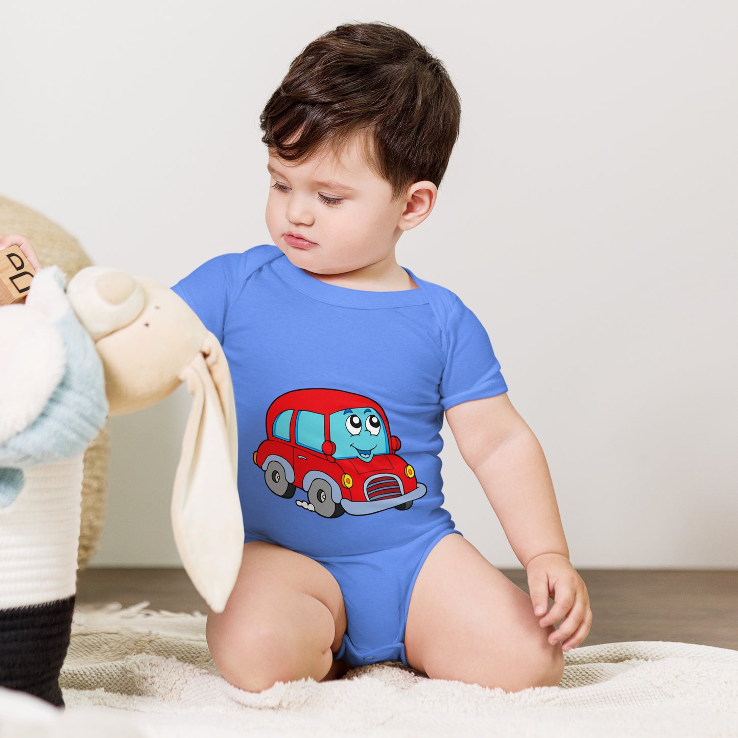 baby with blue short sleeve one piece with picture of a red car