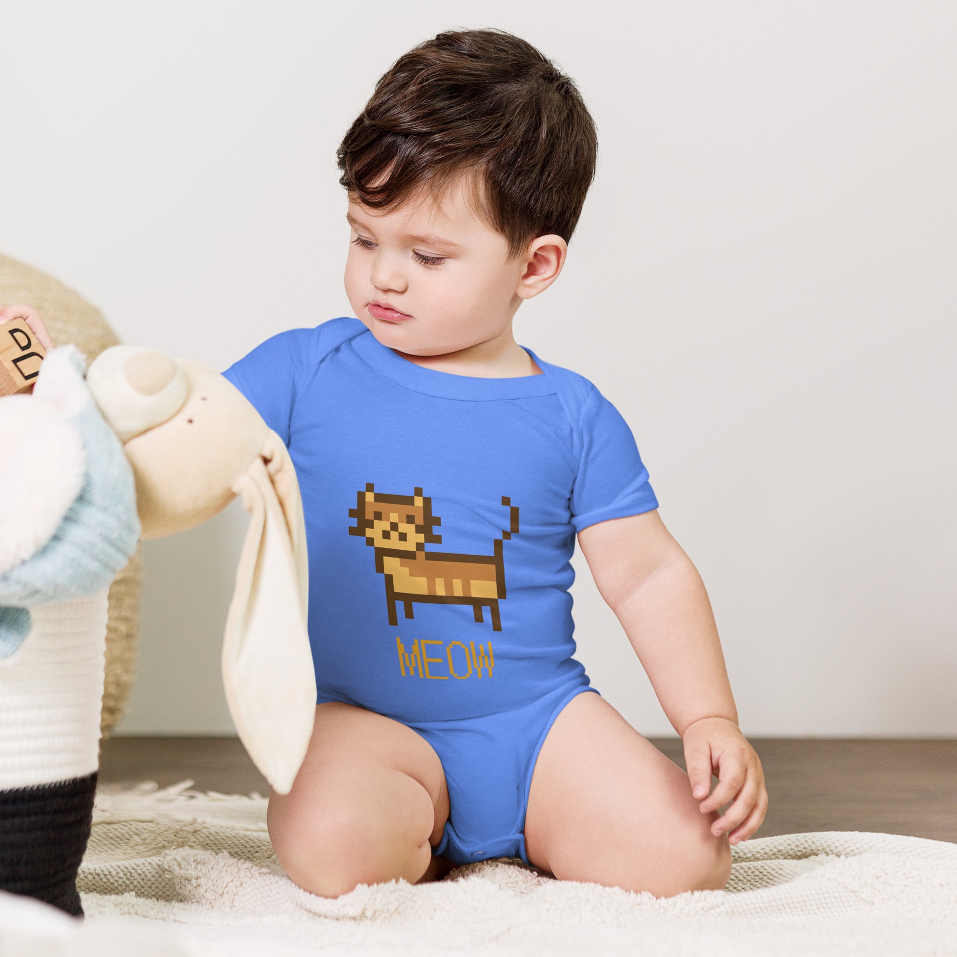 Baby with columbia blue short sleeve one piece with a pixeled picture of a cat and the text MEOW