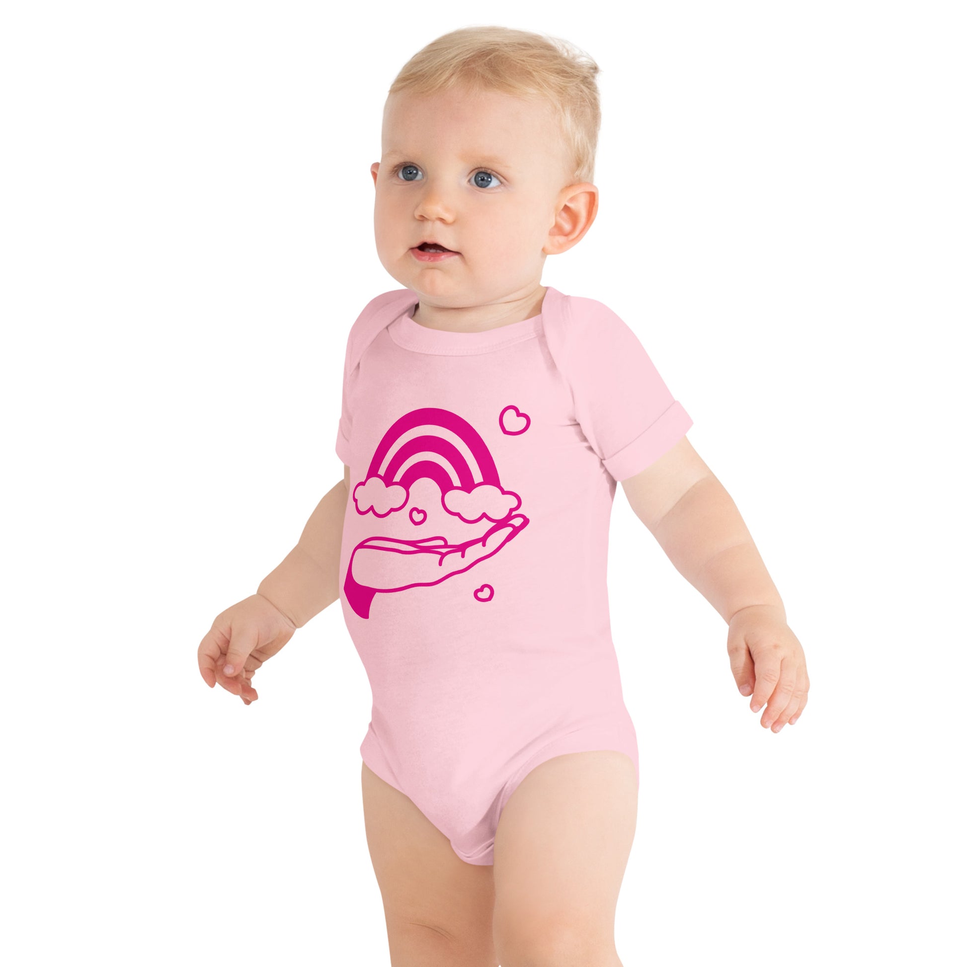 baby with pink short sleeve one piece with print of pink hand holding a pink rainbow