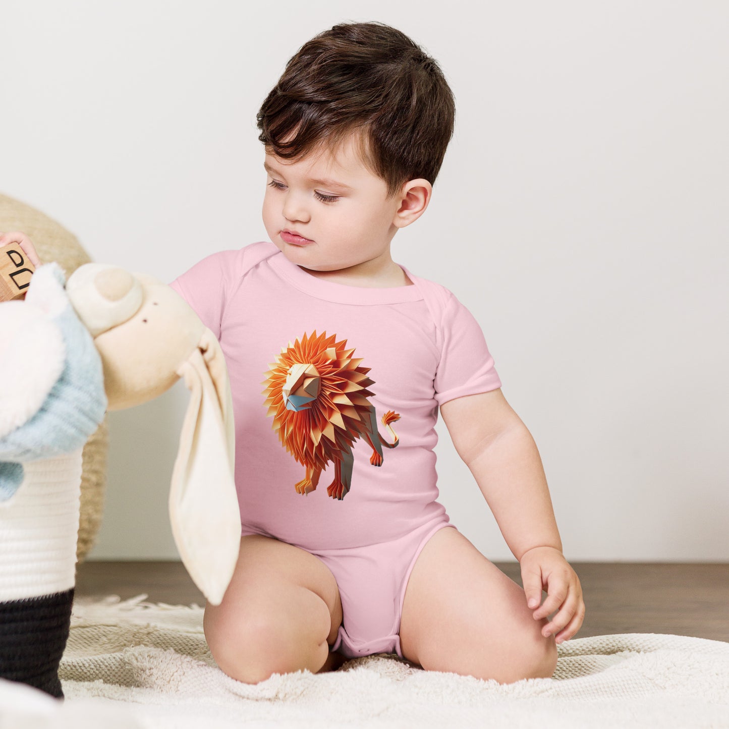 Baby with pink bodysuit with print of a lion