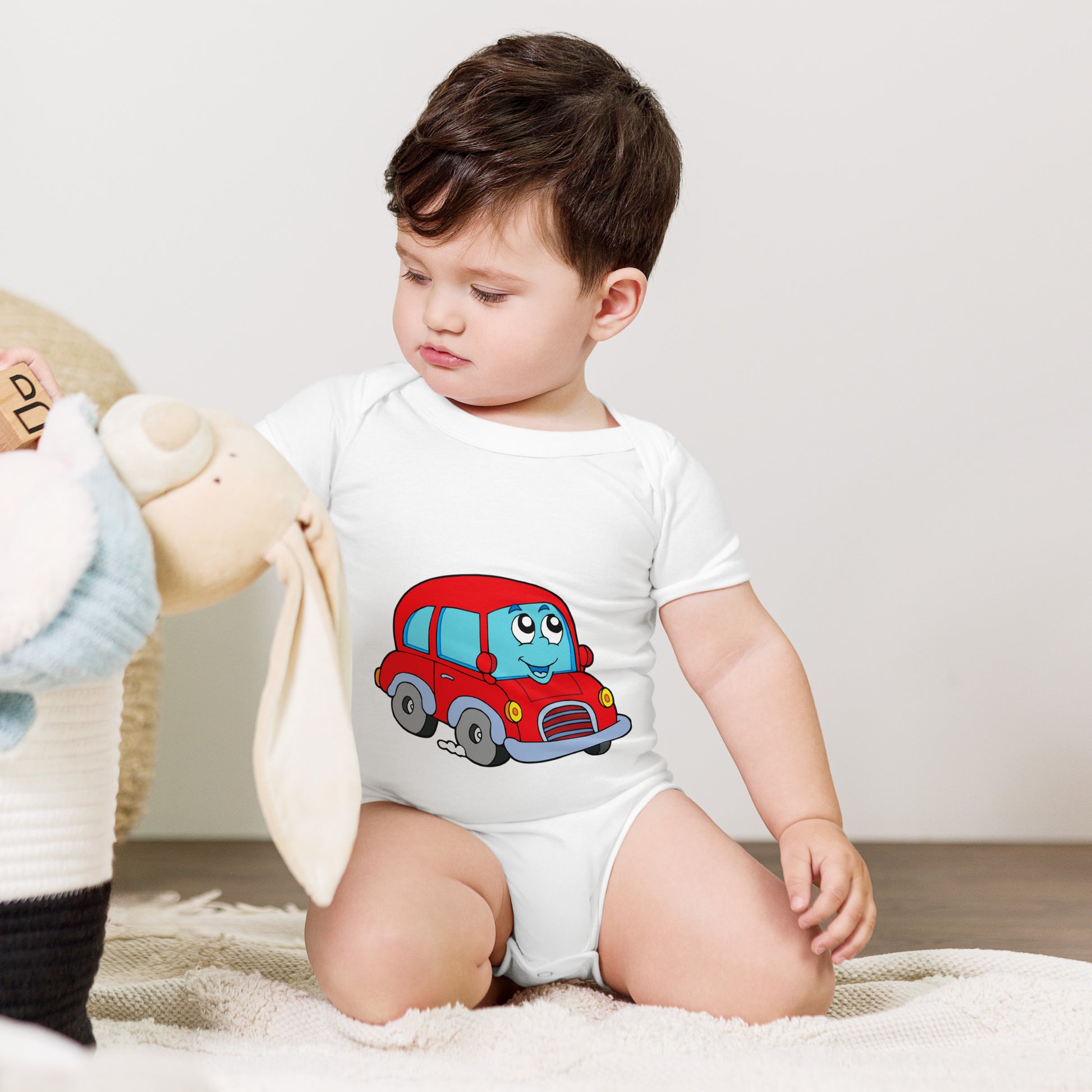 baby with white short sleeve one piece with picture of a red car