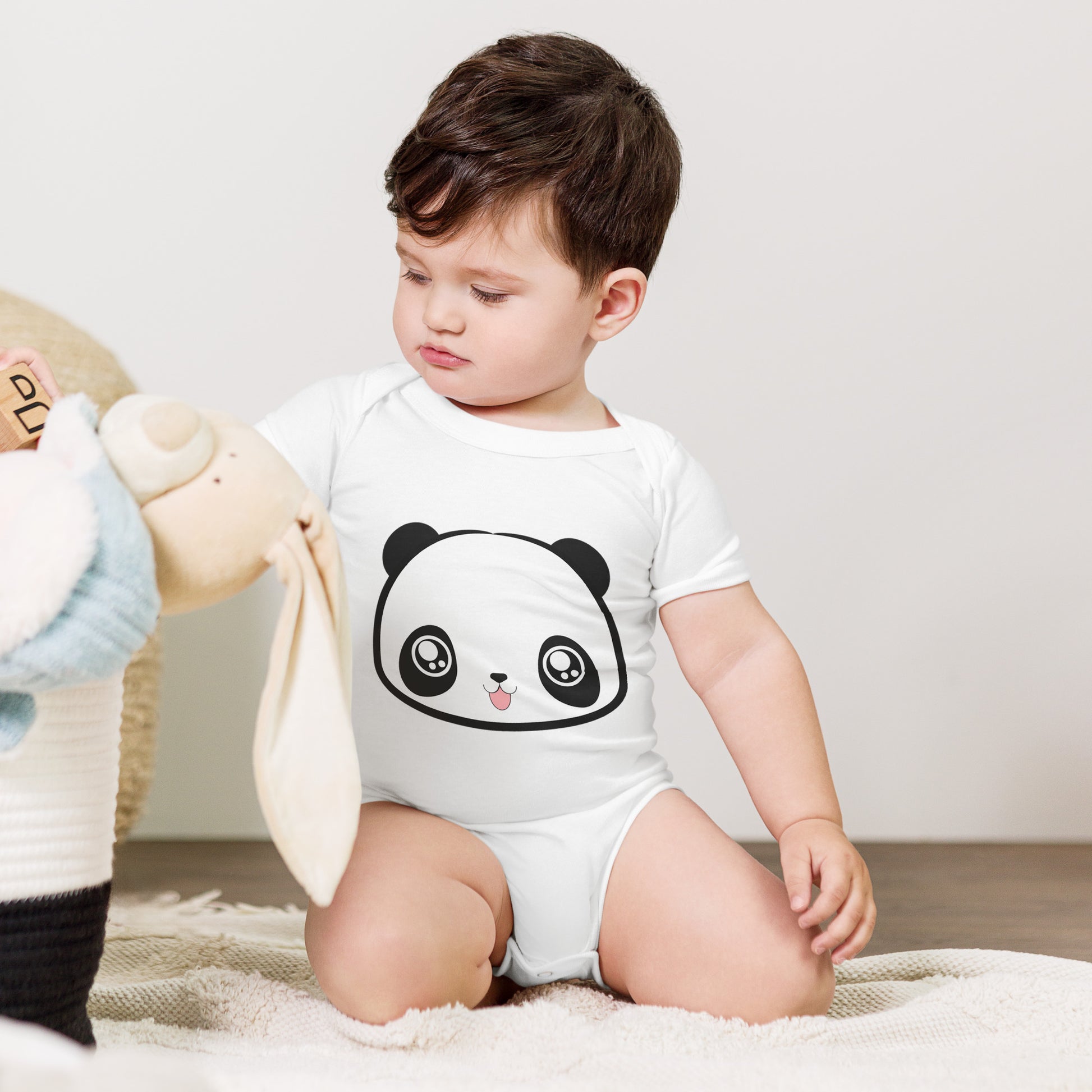 Baby with white babysuit with print of panda head