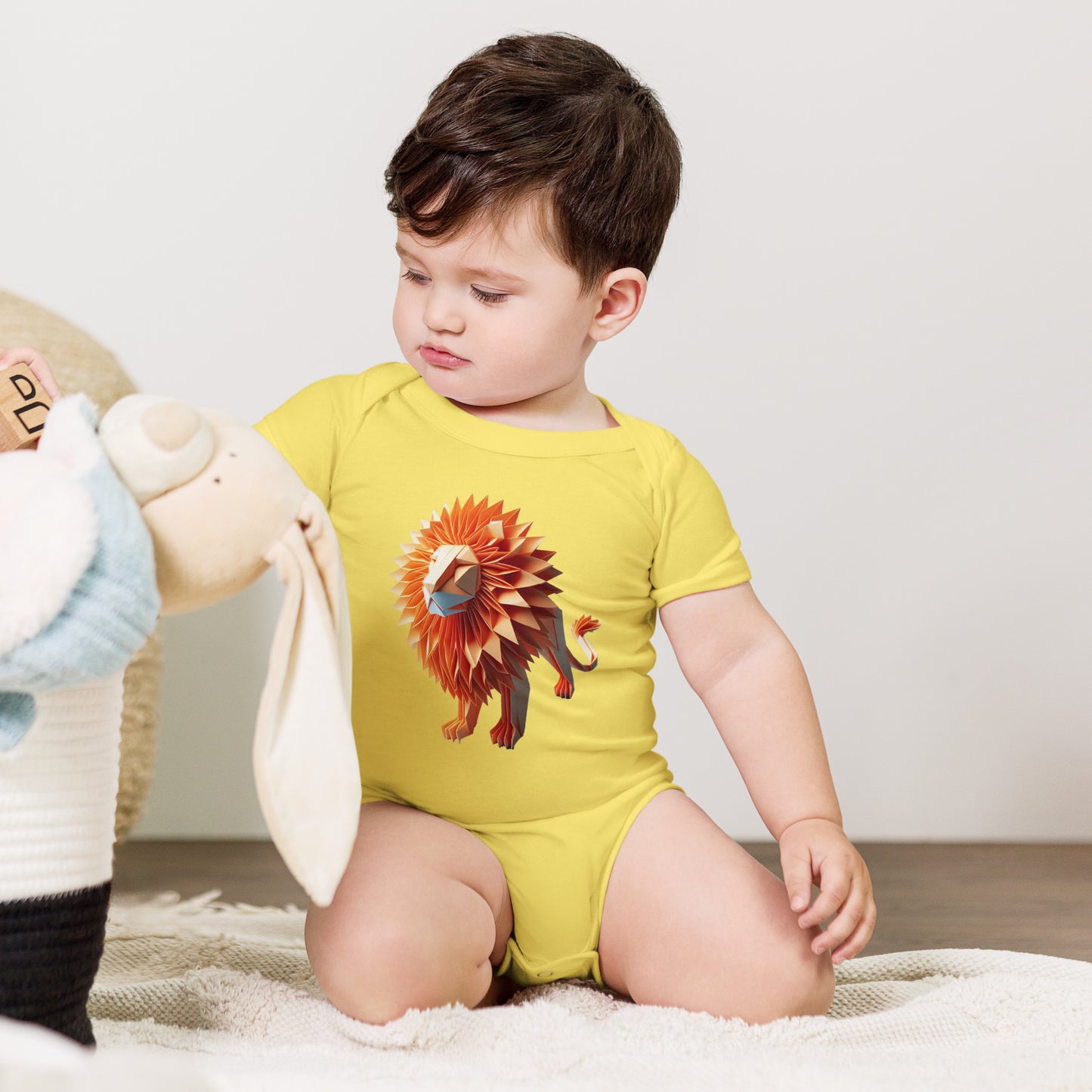 Baby with yellow bodysuit with print of a lion