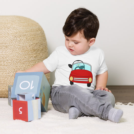 toddler with white t-shirt with picture of penguin driving a red car