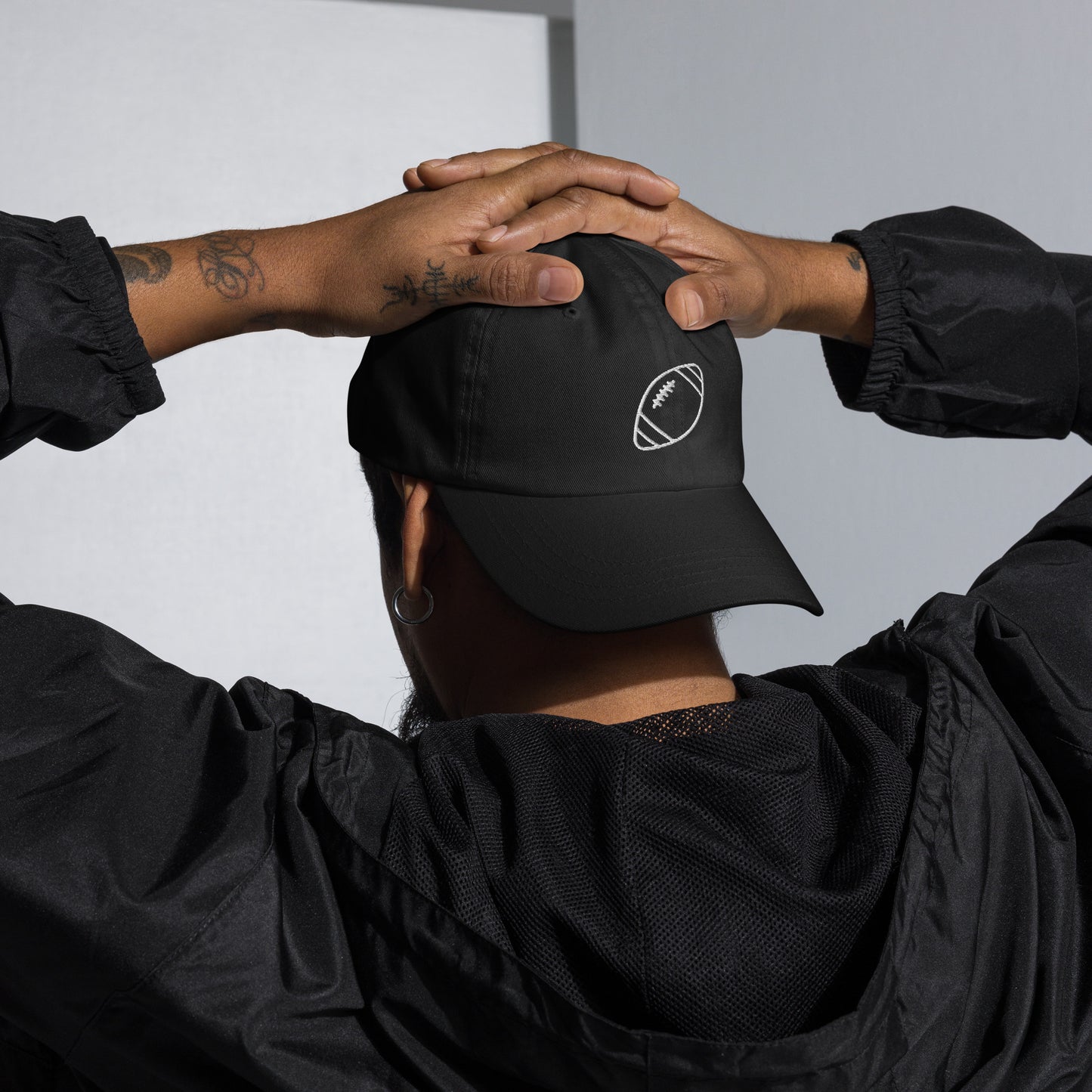 men with black baseball cap with football