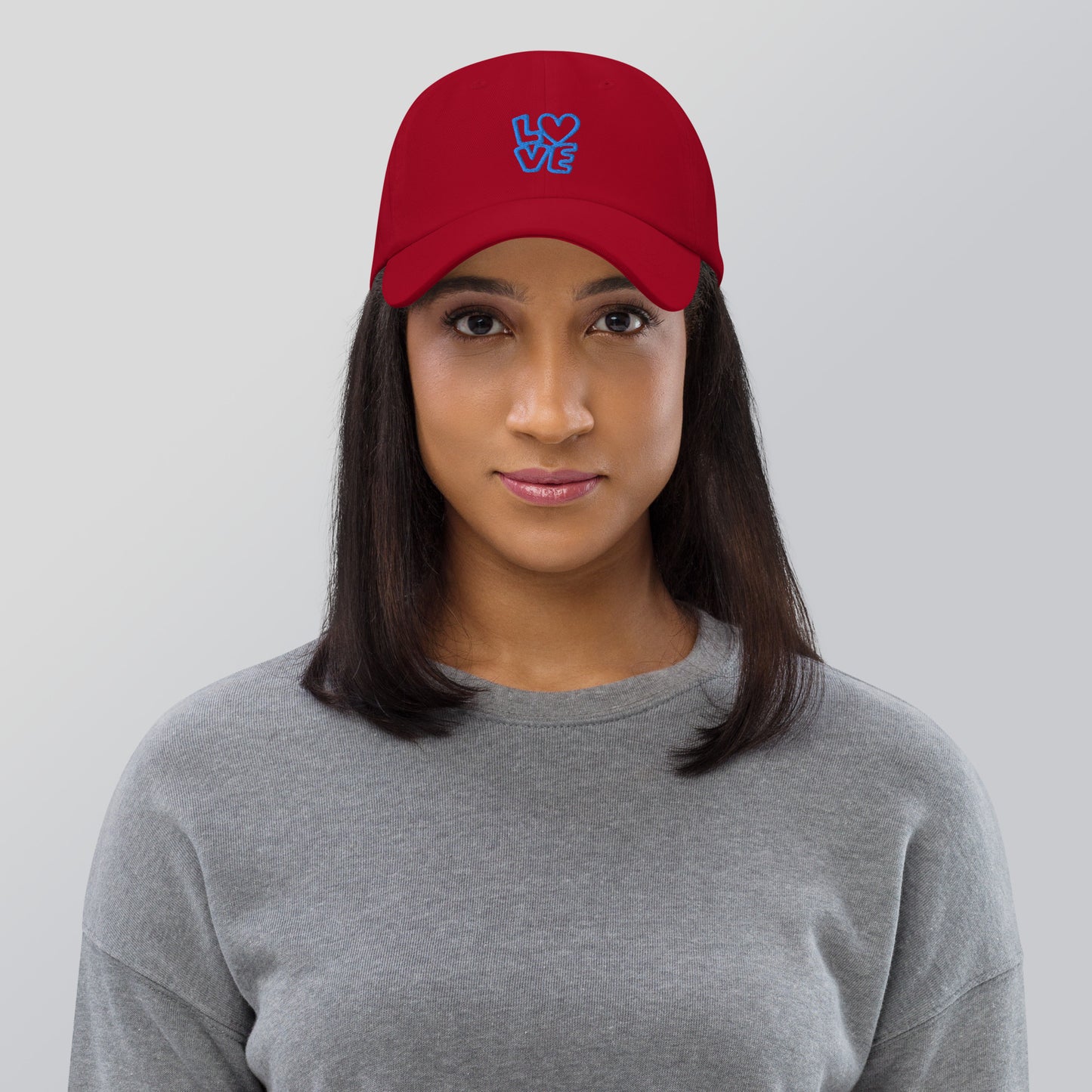 Women with cranberry hat with the blue letters LOVE with the O in heart shape