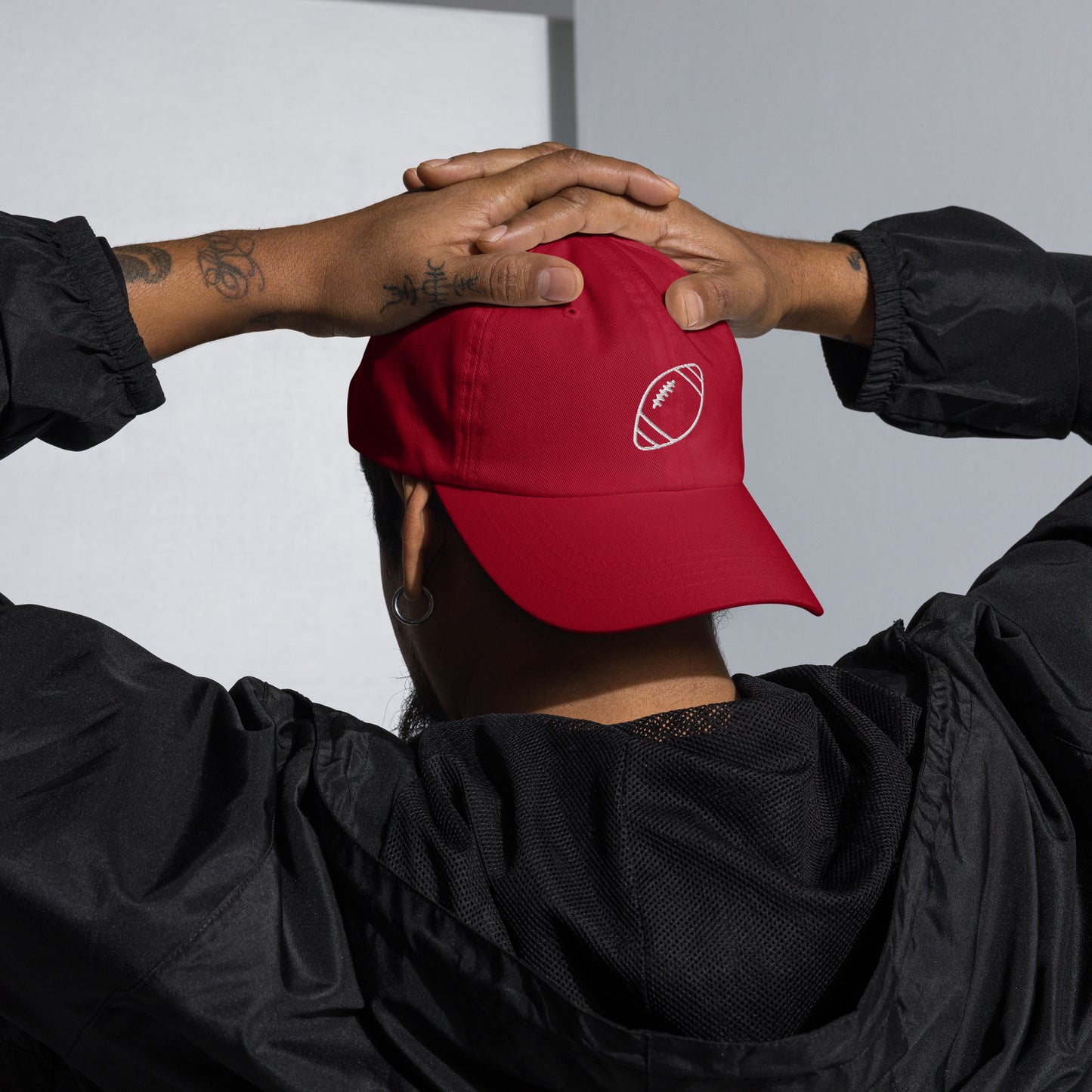 men with red baseball cap with football