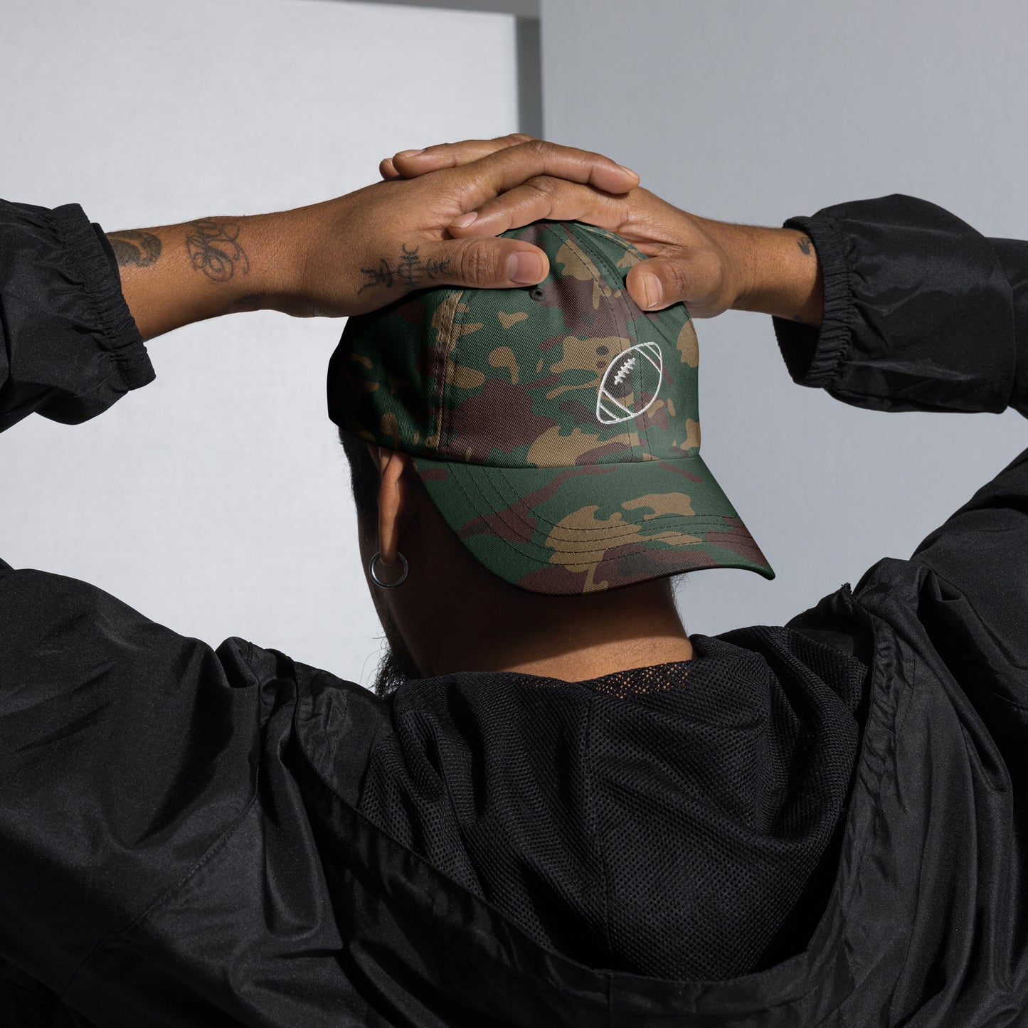 men with green camo baseball cap with football