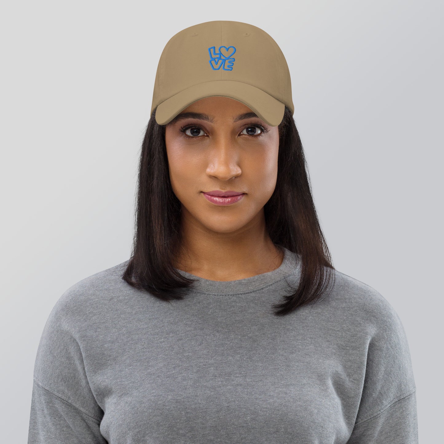 Women with khaki hat with the blue letters LOVE with the O in heart shape