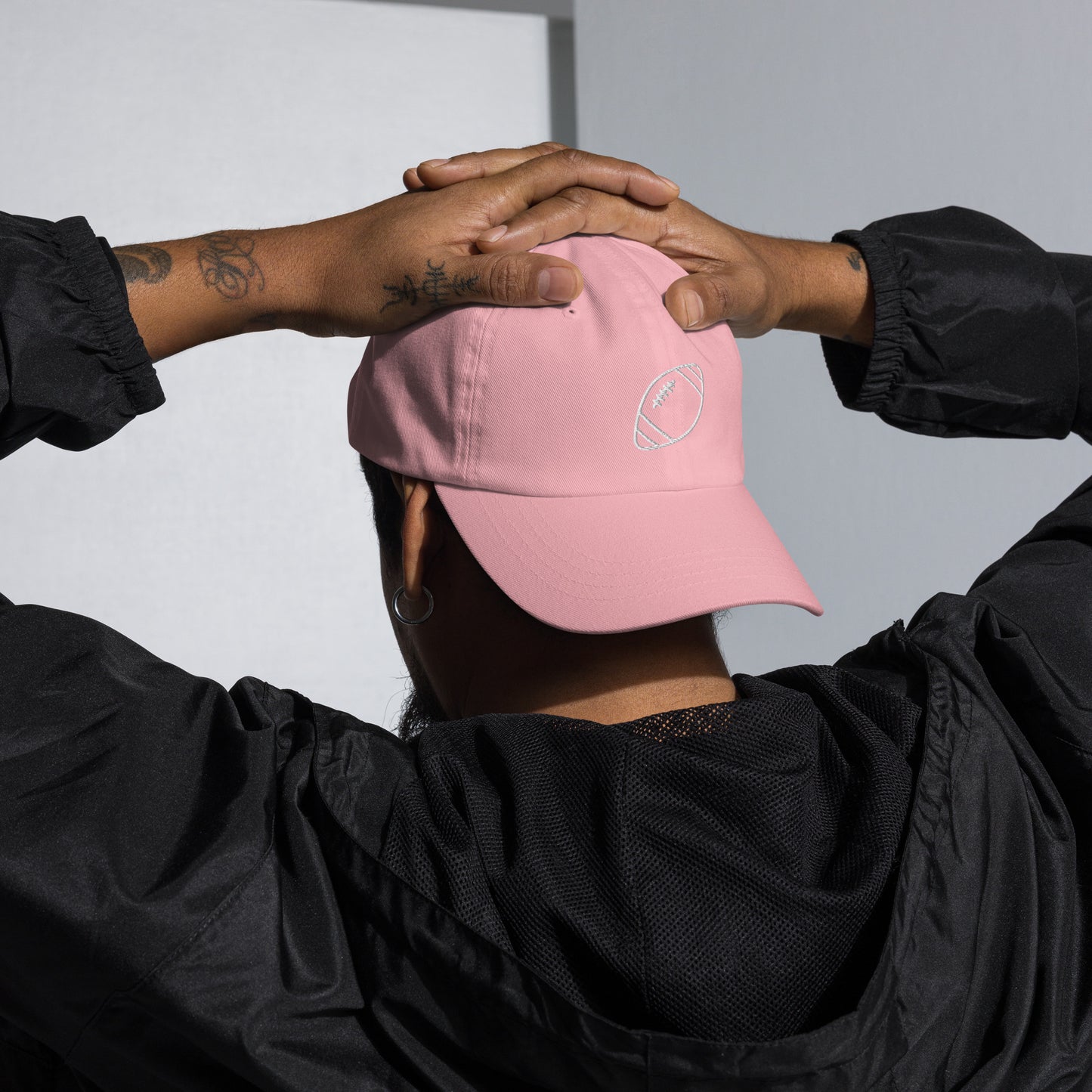 men with pink baseball cap with football