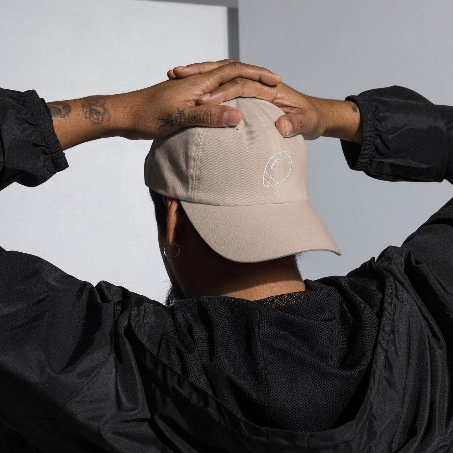 men with stone baseball cap with football