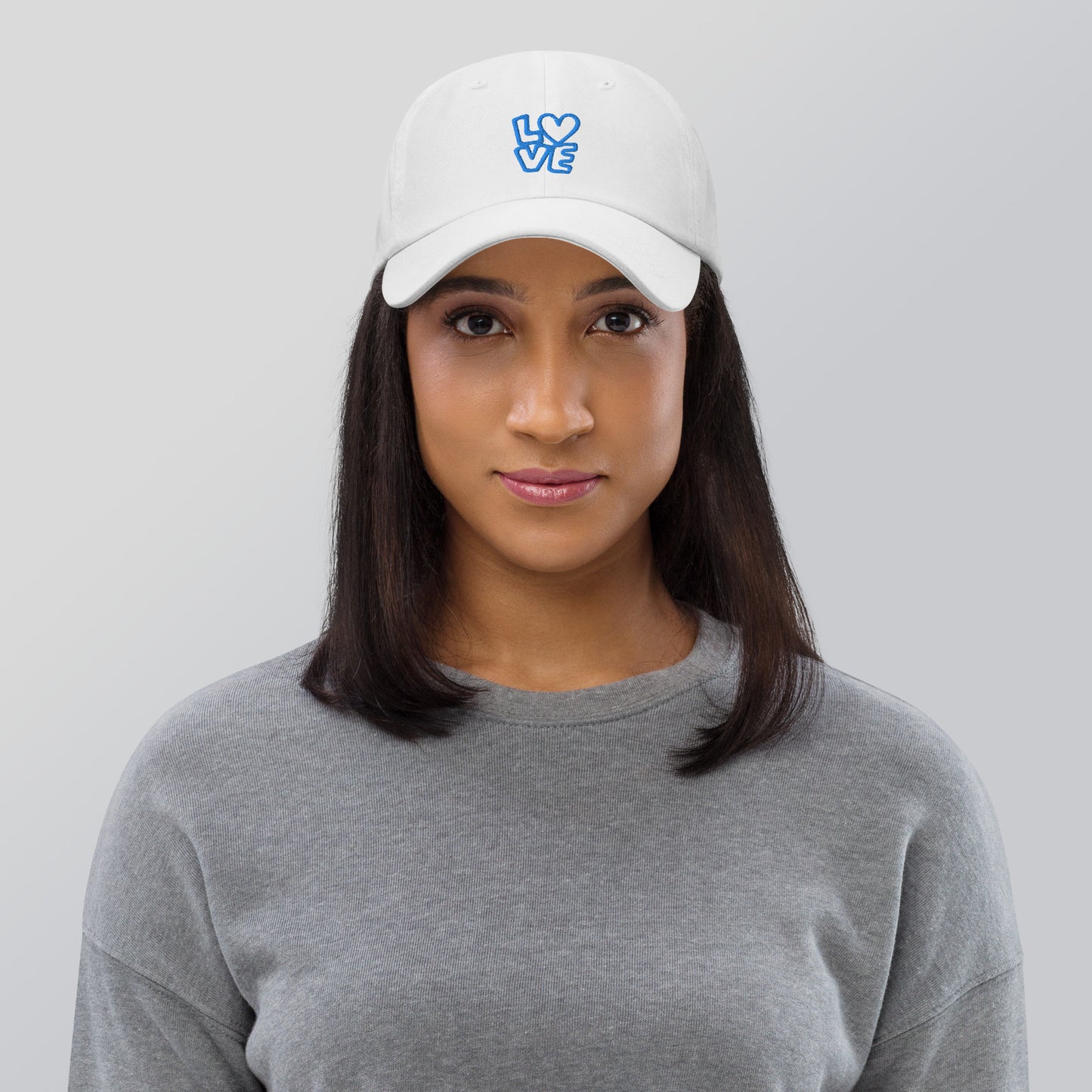 Women with white hat with the blue letters LOVE with the O in heart shape