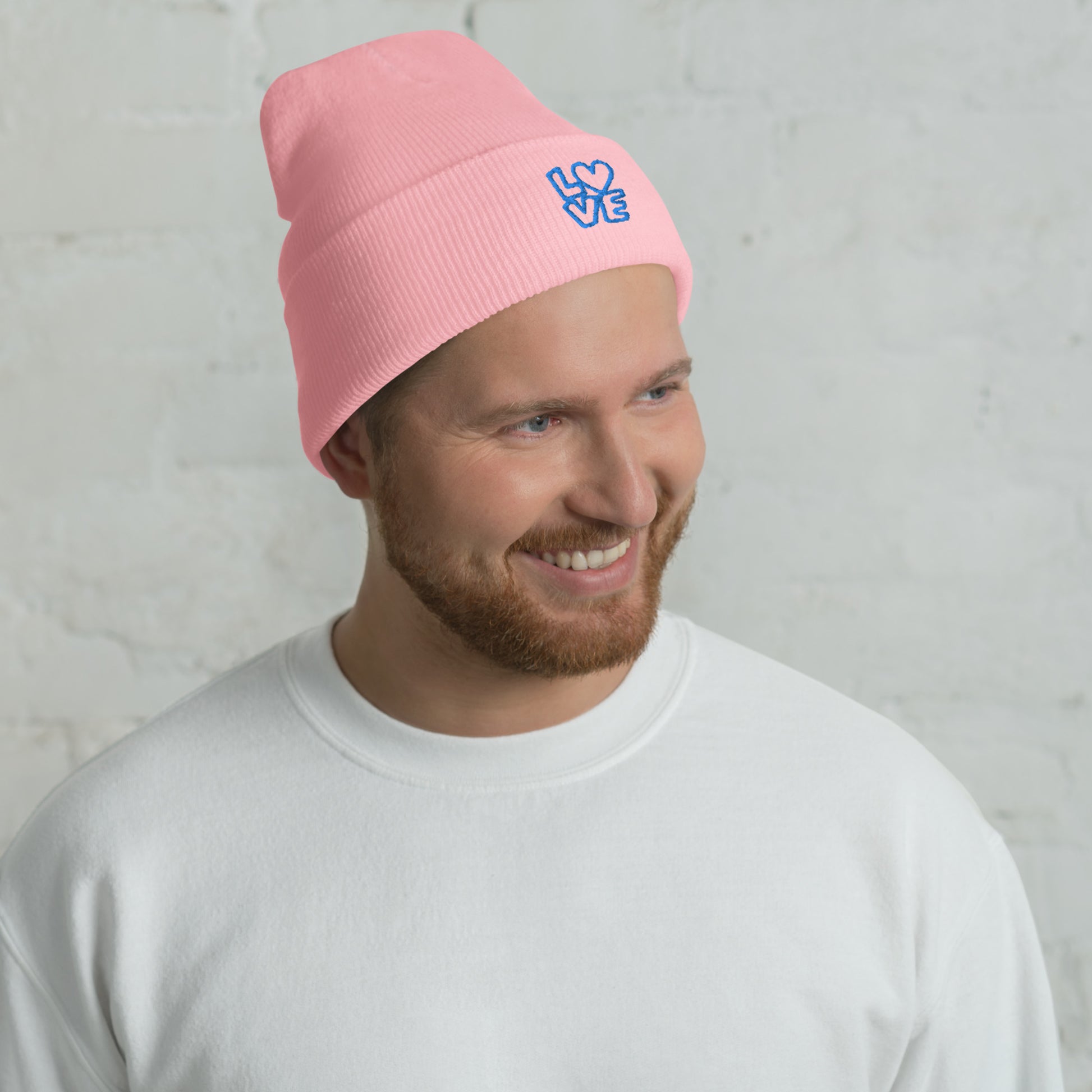 Men with pink beanie with the blue letters LOVE with the O in heart shape