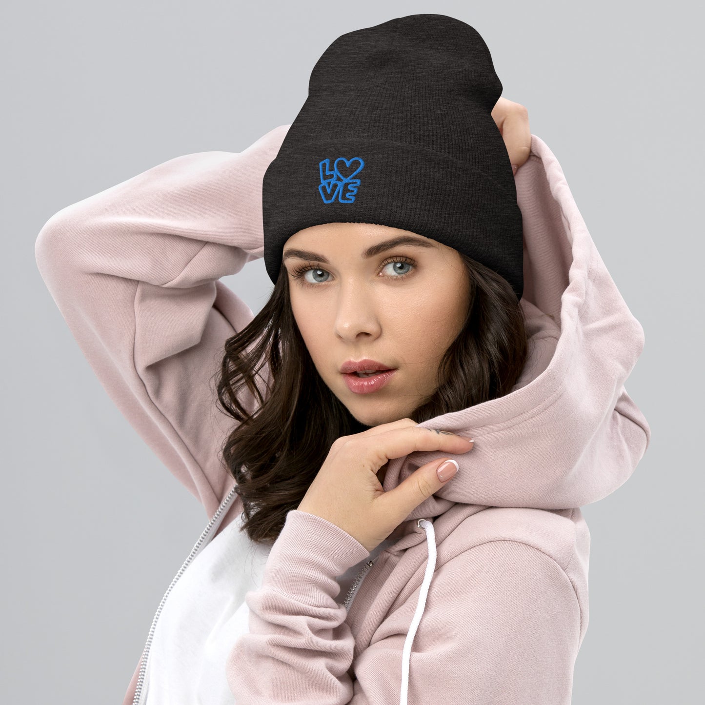 Women with dark grey beanie with the blue letters LOVE with the O in heart shape