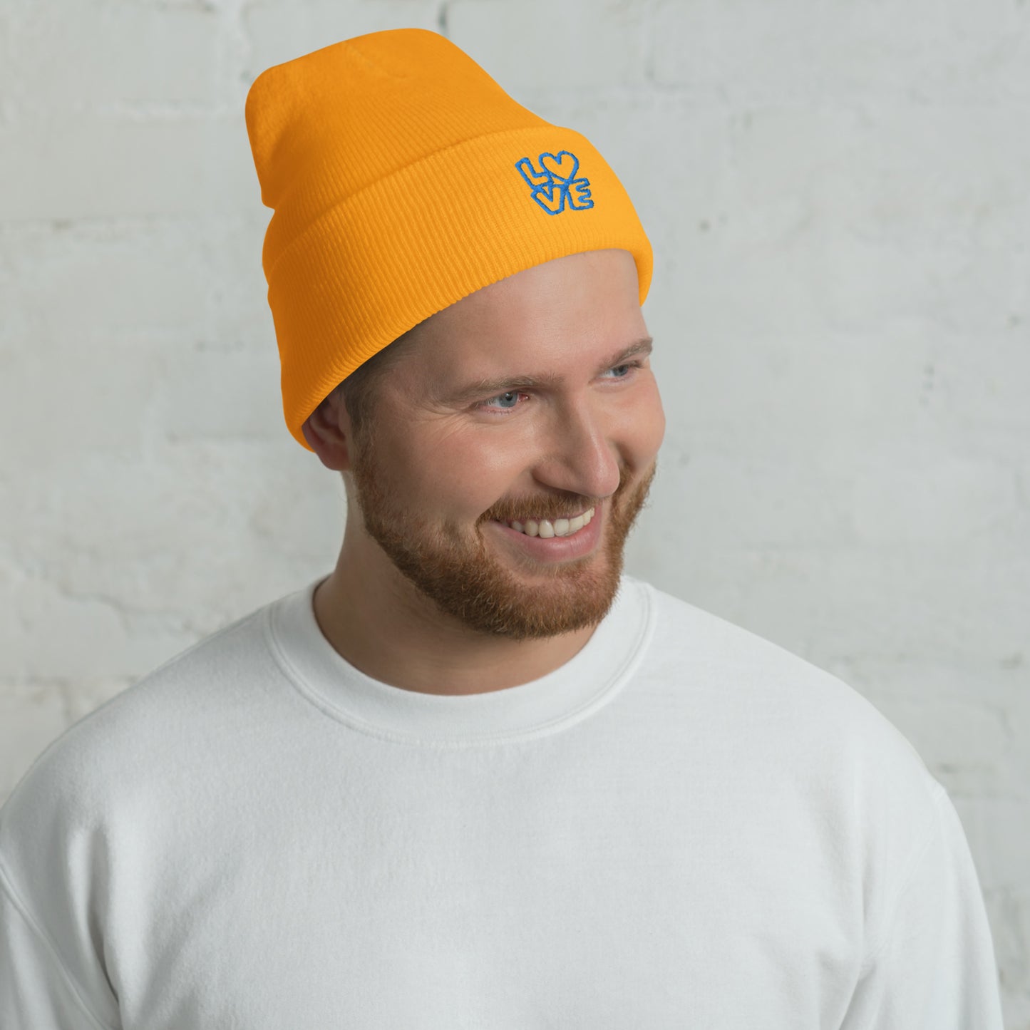 Men with yellow gold beanie with the blue letters LOVE with the O in heart shape