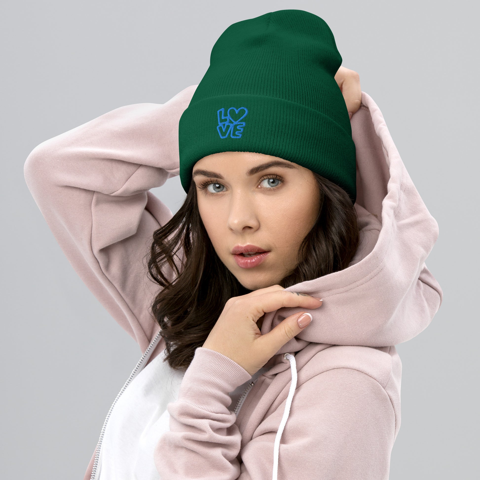 Women with green beanie with the blue letters LOVE with the O in heart shape