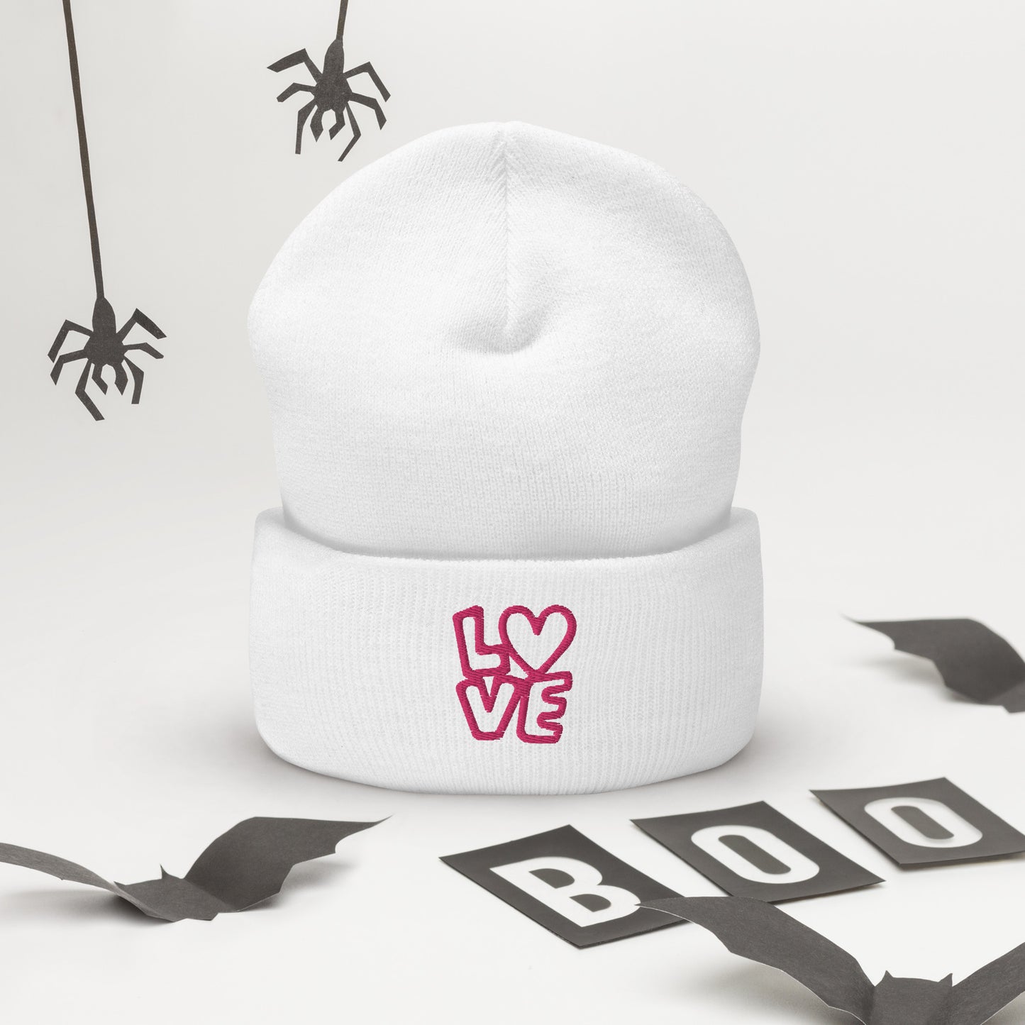 White beanie with the pink letters LOVE with the O in heart shape