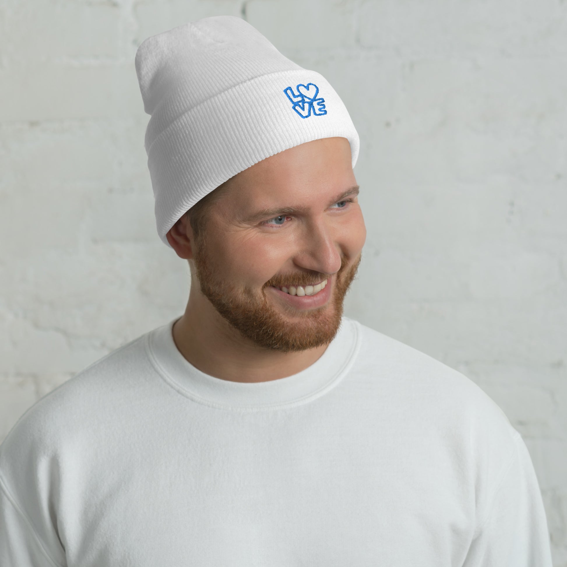 Men with white beanie with the blue letters LOVE with the O in heart shape