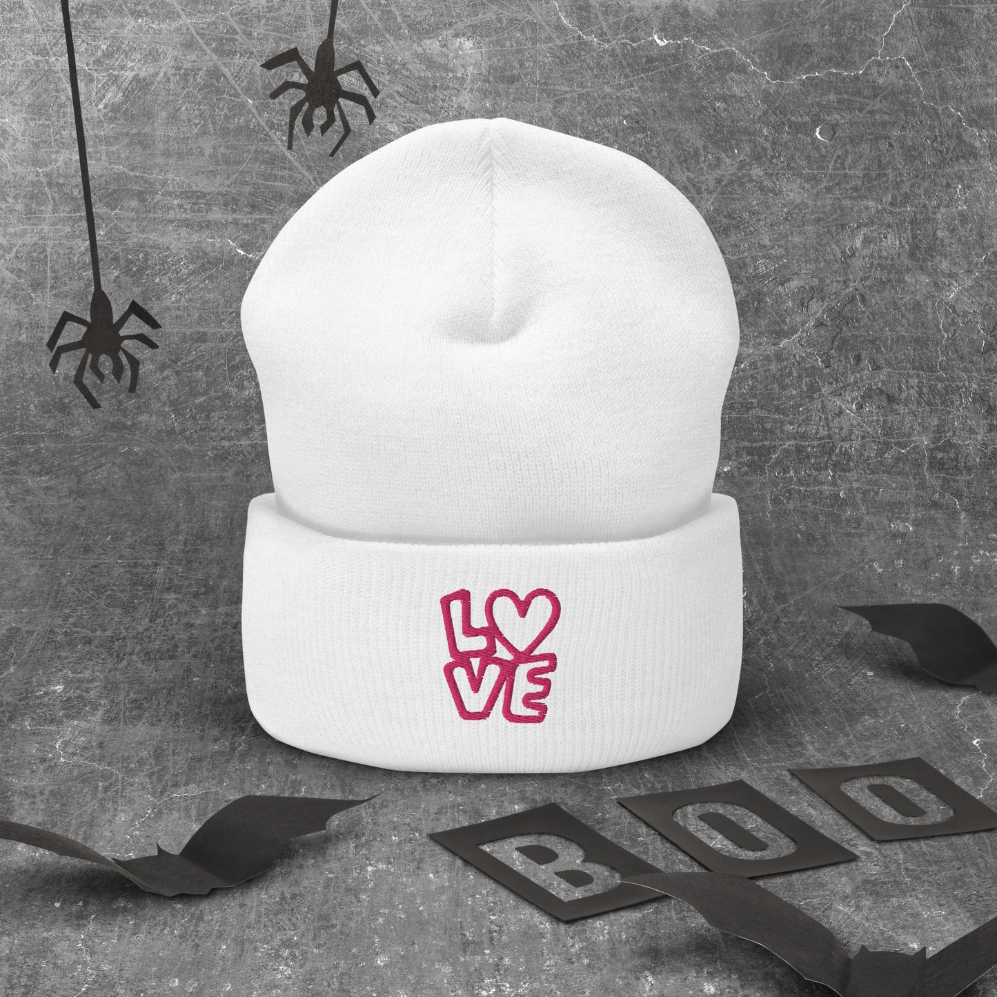 White beanie with the pink letters LOVE with the O in heart shape