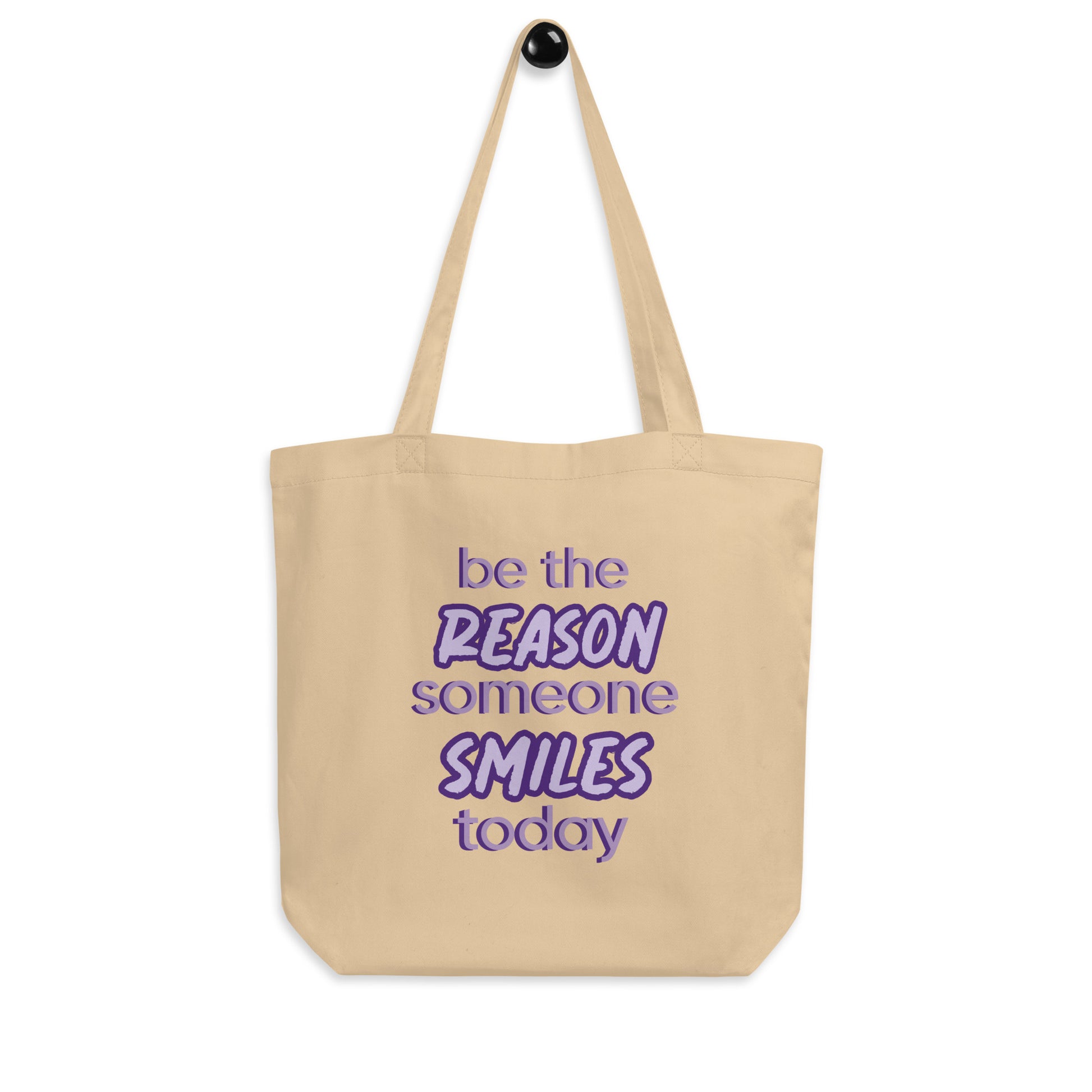 Oyster tote bag with the quote "be the reason someone smiles today" in purple on it. 