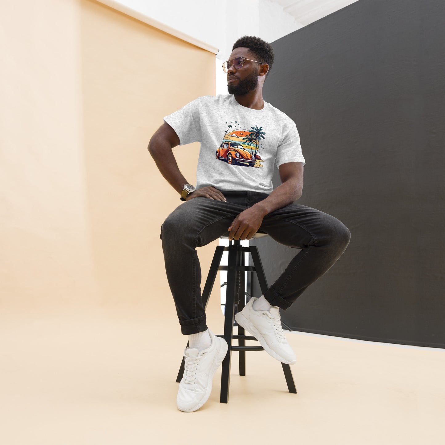 man with grey t-shirt with picture of beetle car in front of palm trees