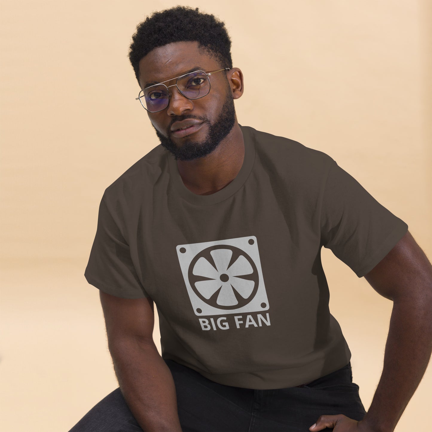 Man with dark brown t-shirt with image of a big computer fan and the text "BIG FAN"