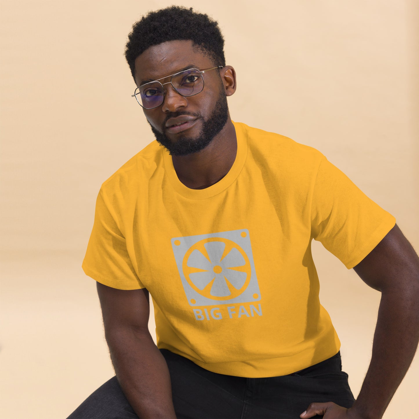 Man with gold t-shirt with image of a big computer fan and the text "BIG FAN"