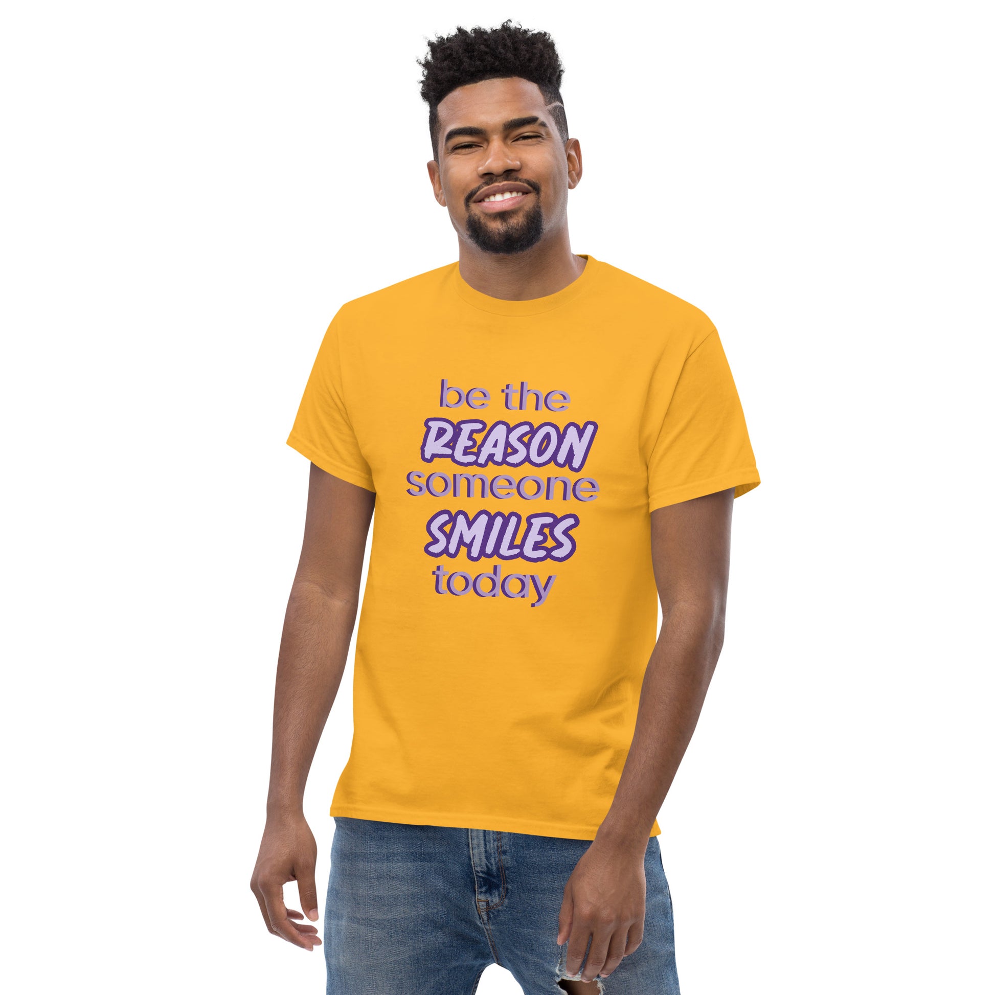 Men with gold T-shirt and the quote "be the reason someone smiles today" in purple on it. 