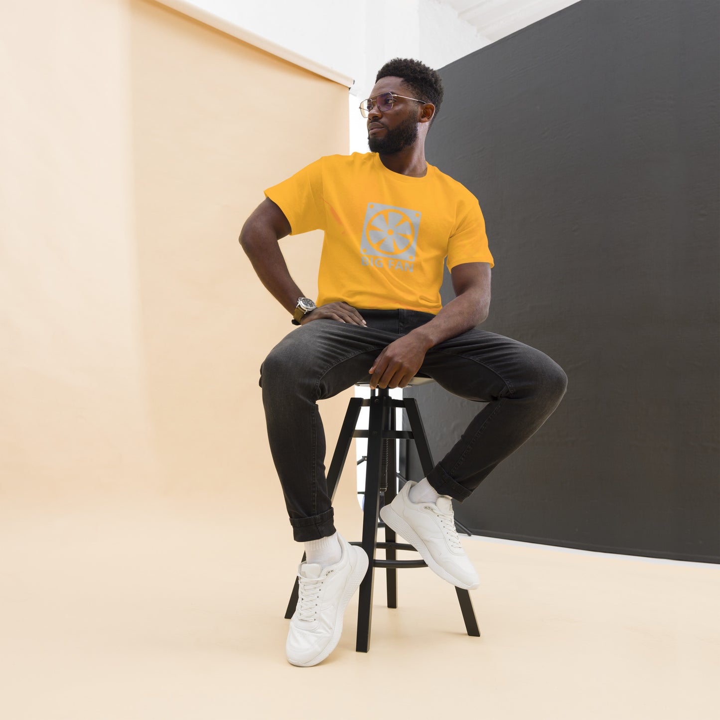 Man with gold t-shirt with image of a big computer fan and the text "BIG FAN"