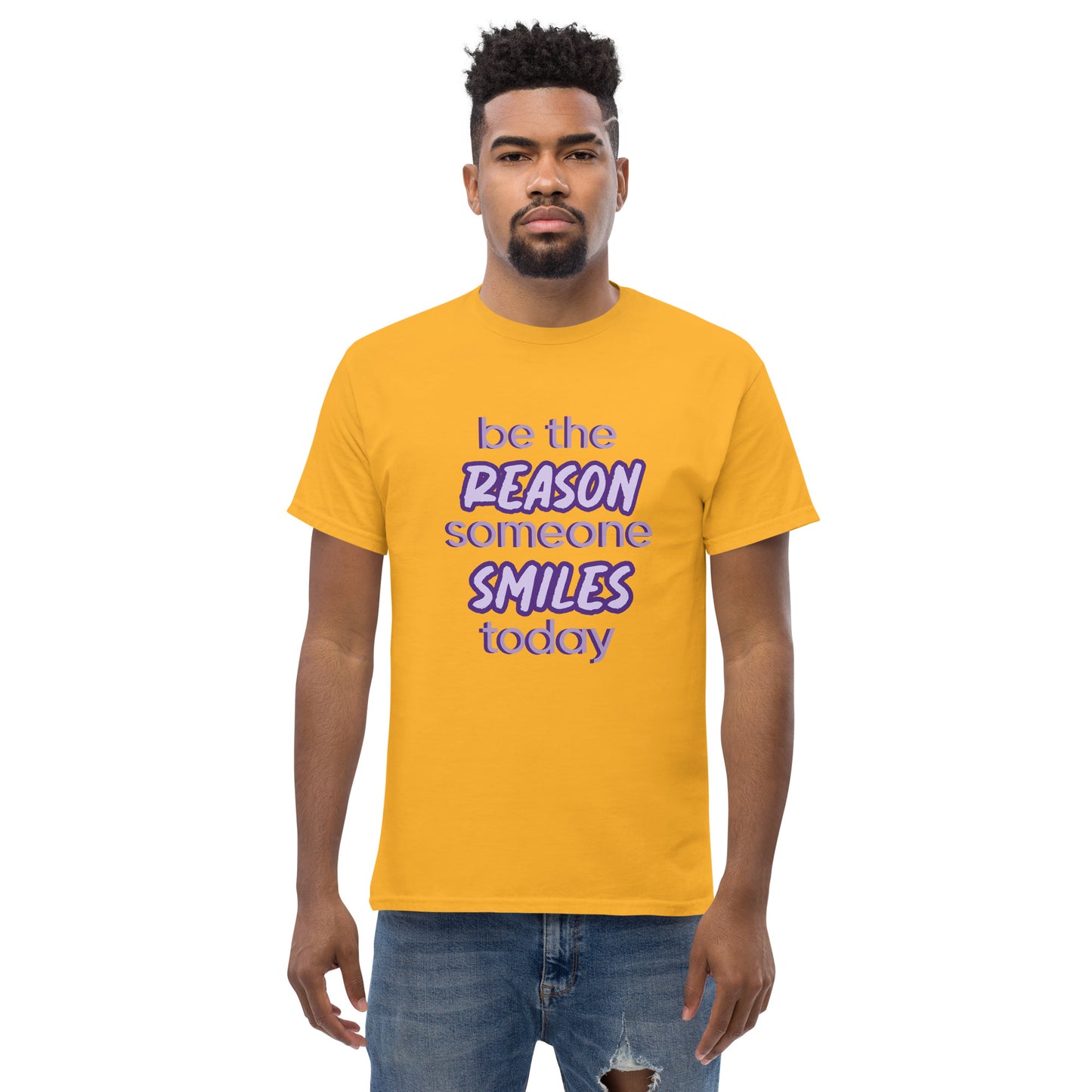 Men with gold T-shirt and the quote "be the reason someone smiles today" in purple on it.