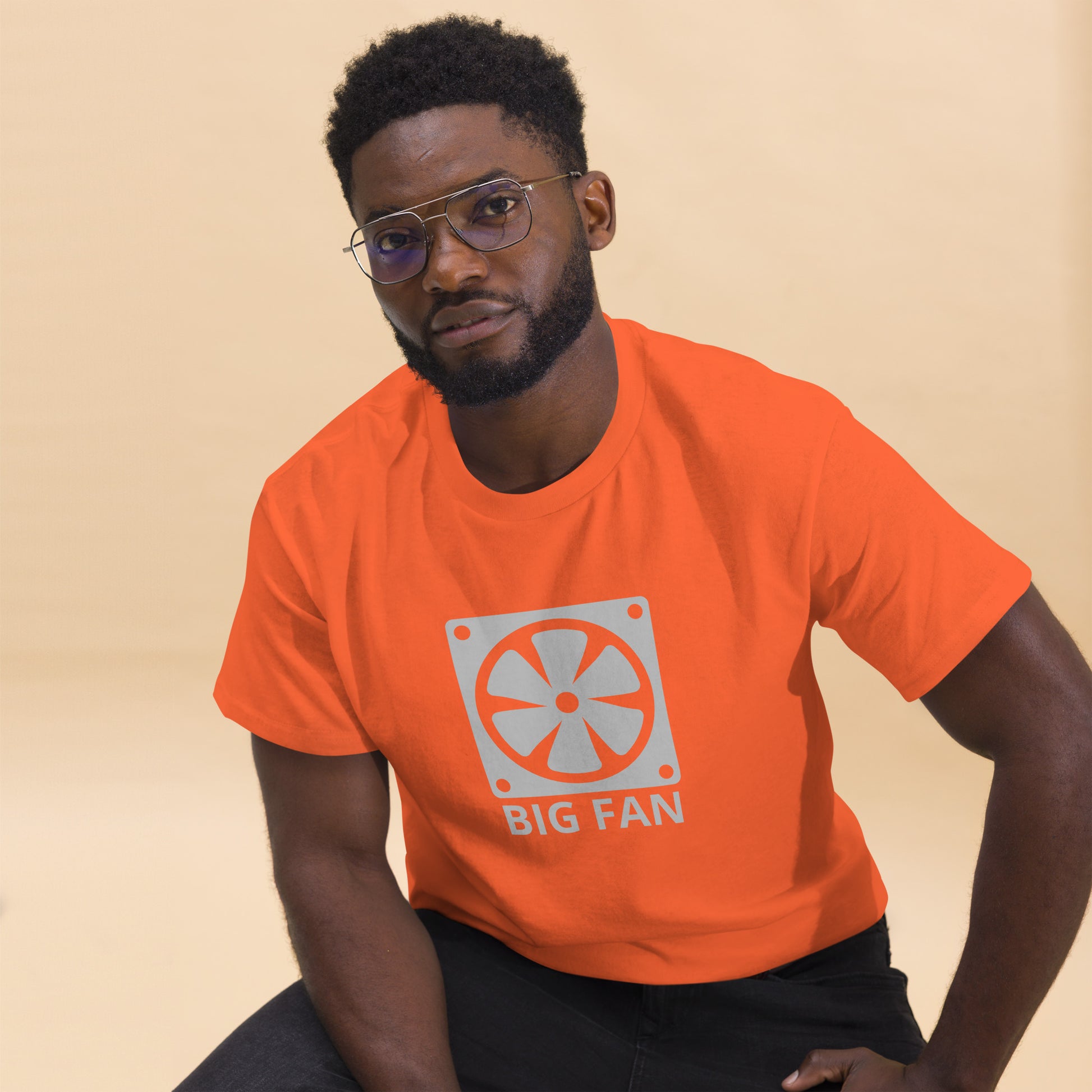 Man with orange t-shirt with image of a big computer fan and the text "BIG FAN"
