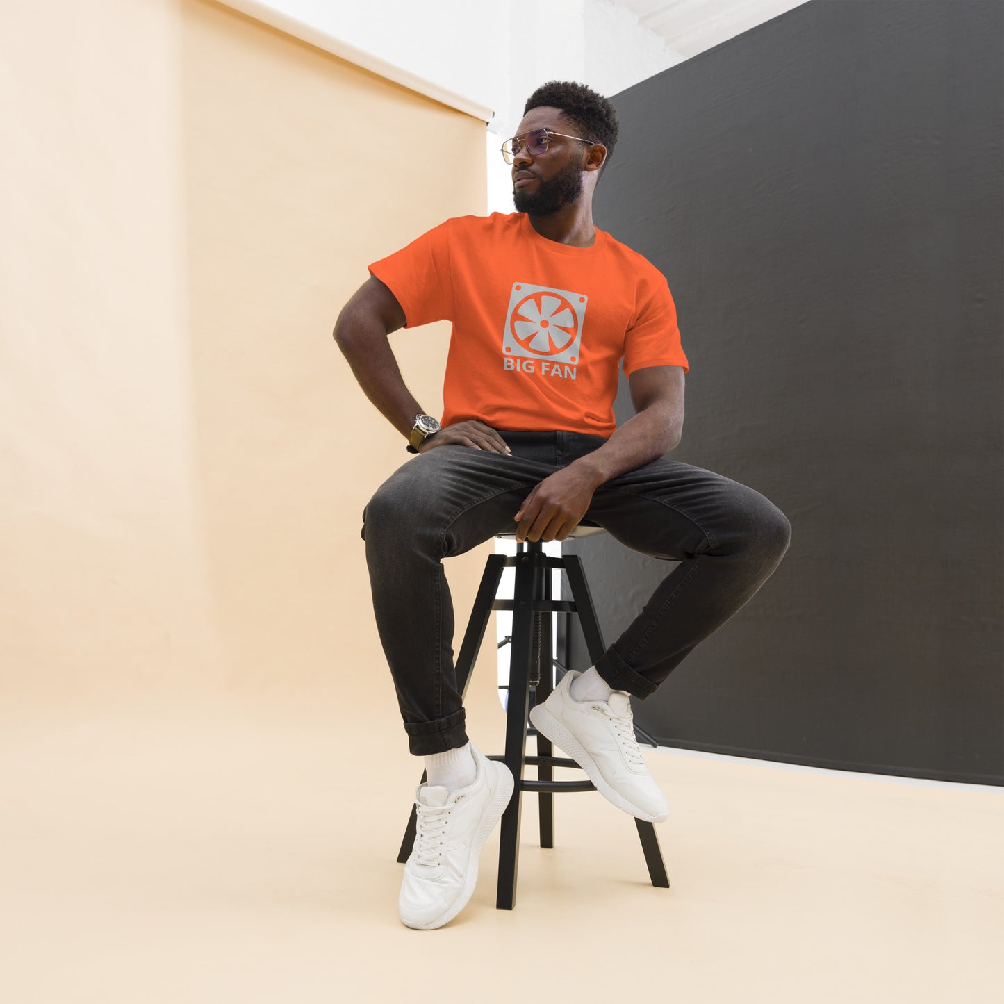 Man with orange t-shirt with image of a big computer fan and the text "BIG FAN"