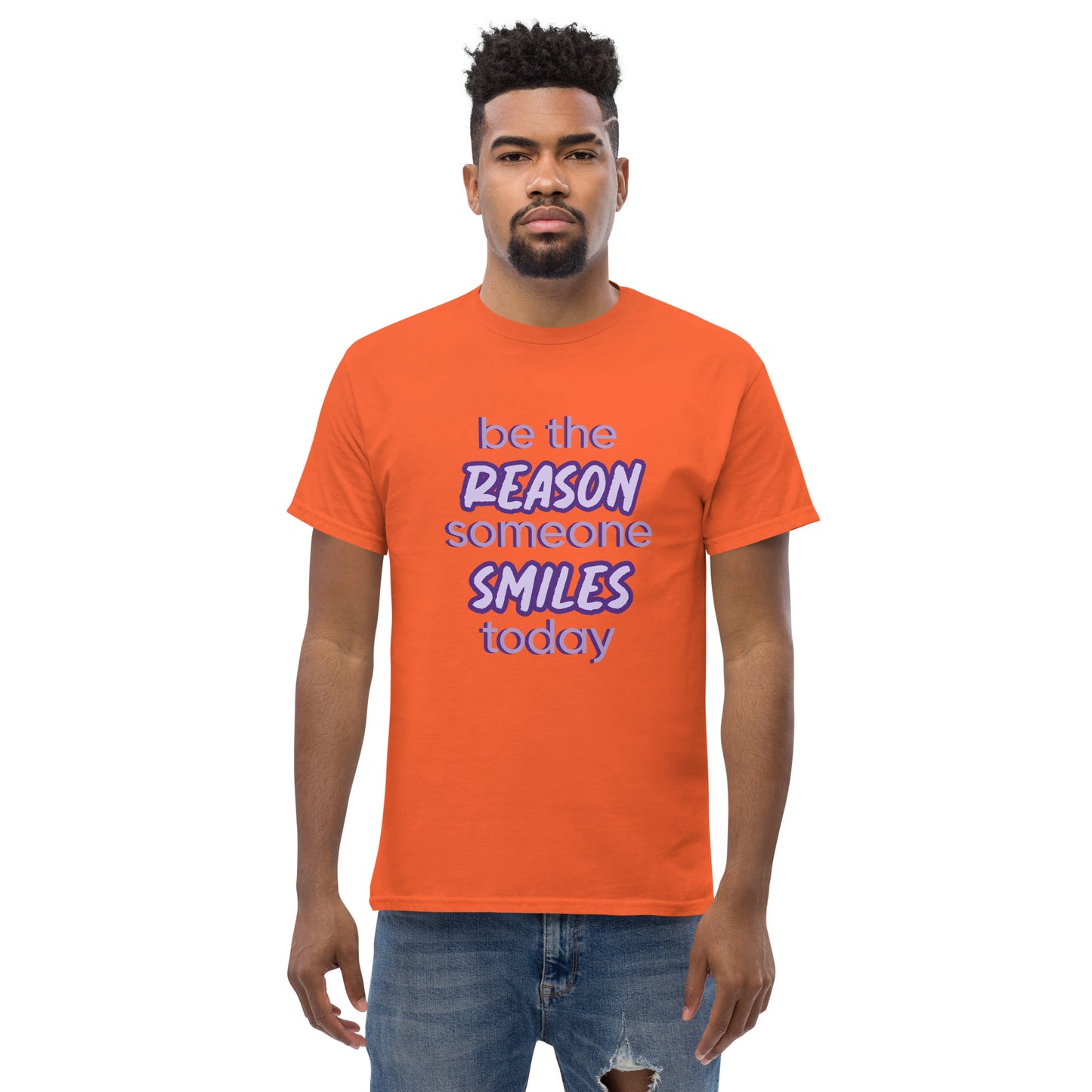 Men with orange T-shirt and the quote "be the reason someone smiles today" in purple on it. 