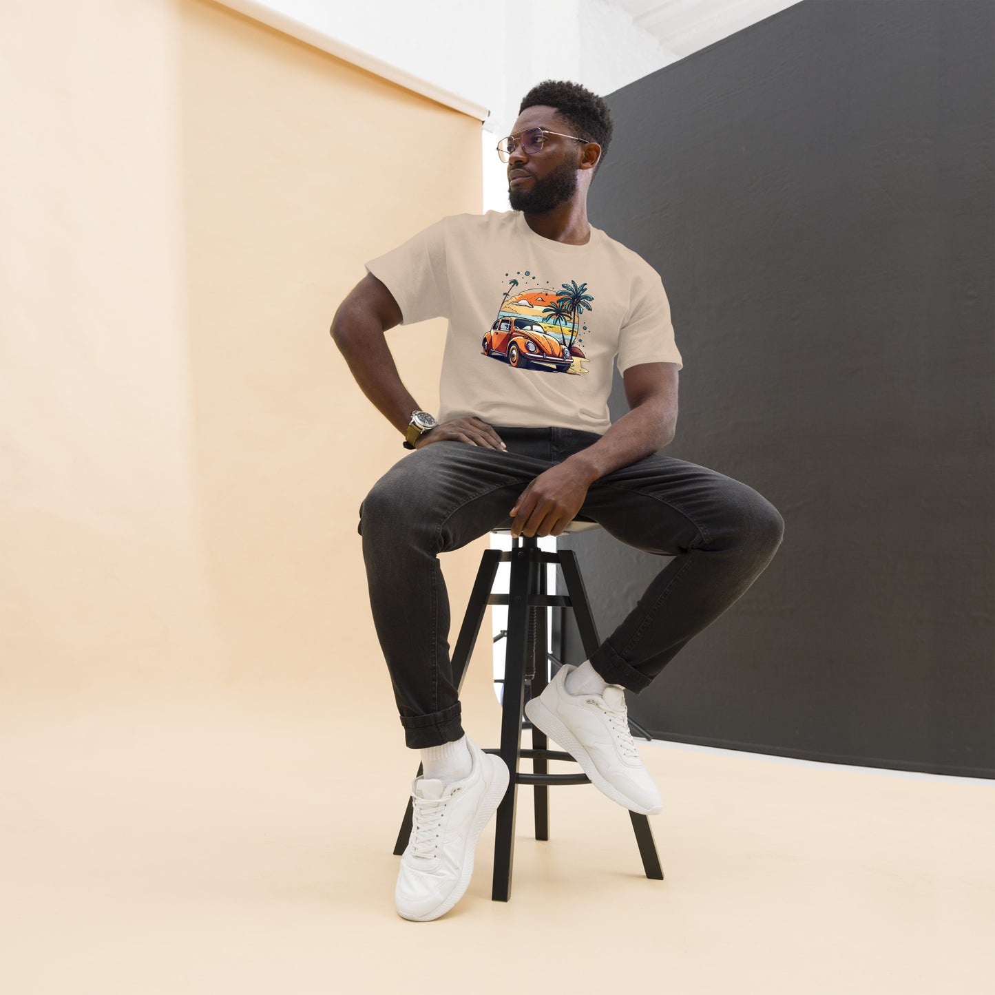 man with sand t-shirt with picture of beetle car in front of palm trees