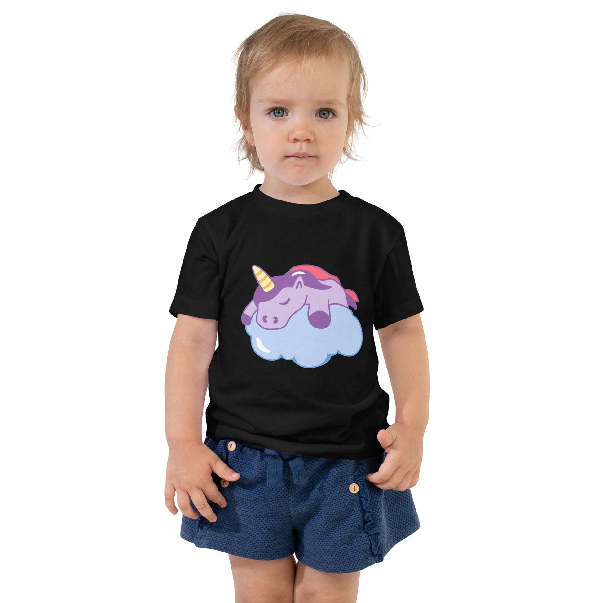 Toddler with a black T-shirt with a print of a sleeping unicorn on a cloud