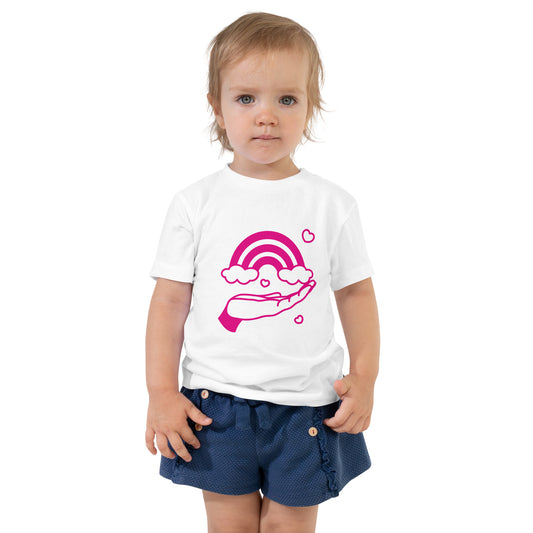 toddler with white t-shirt with print of pink hand holding a pink rainbow