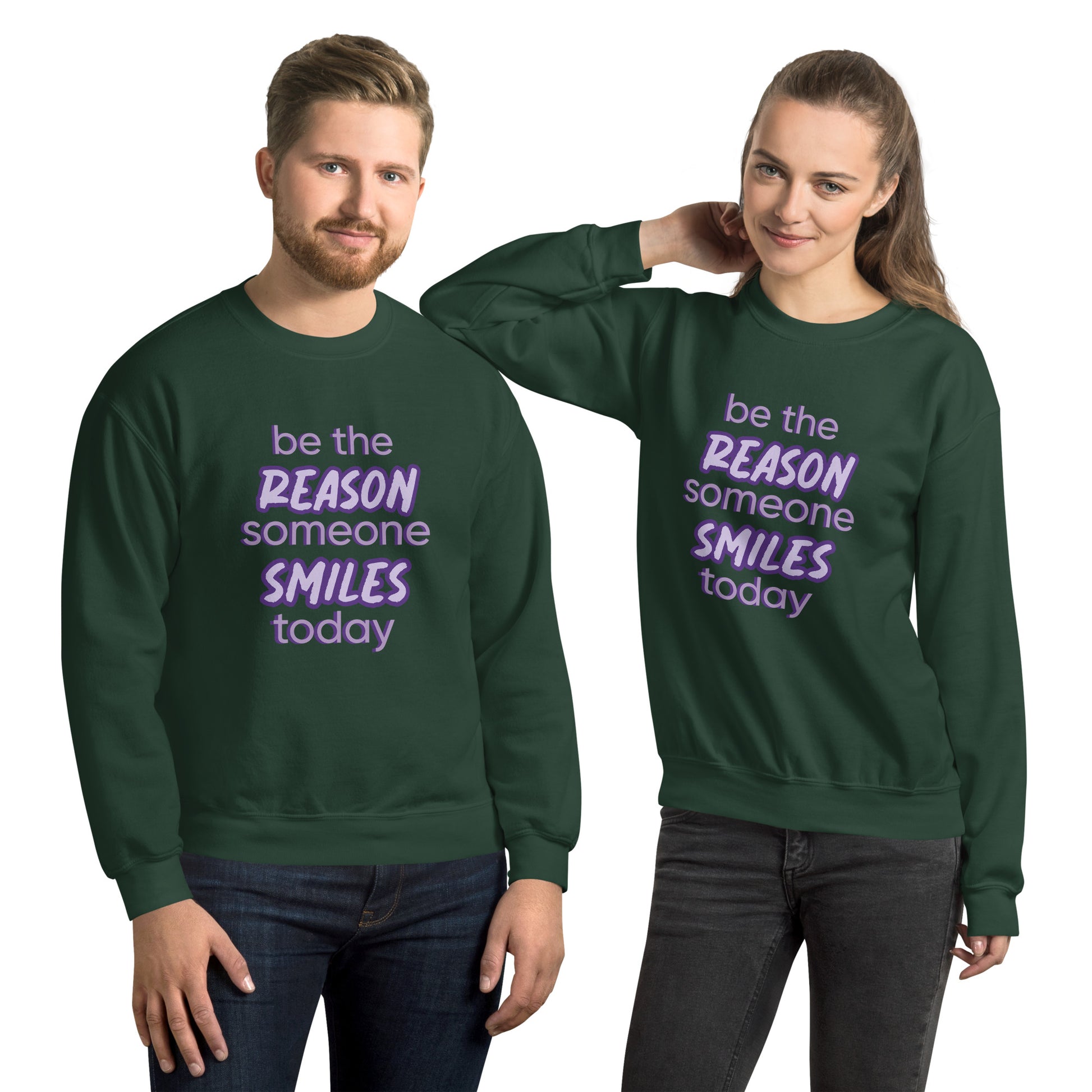 Men and women with forest green sweater and the quote "be the reason someone smiles today" in purple on it. 