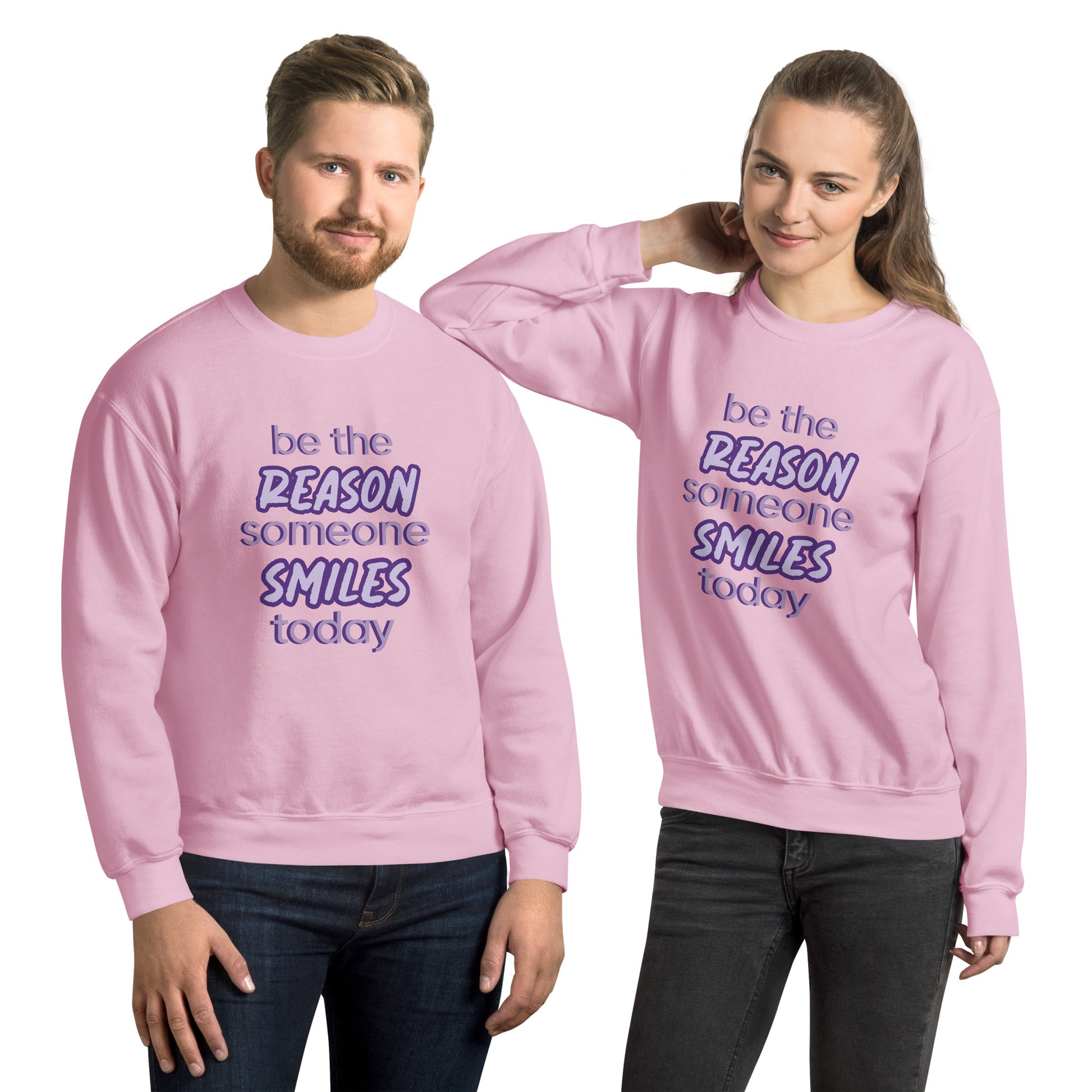 Men and women with light pink sweater and the quote "be the reason someone smiles today" in purple on it. 