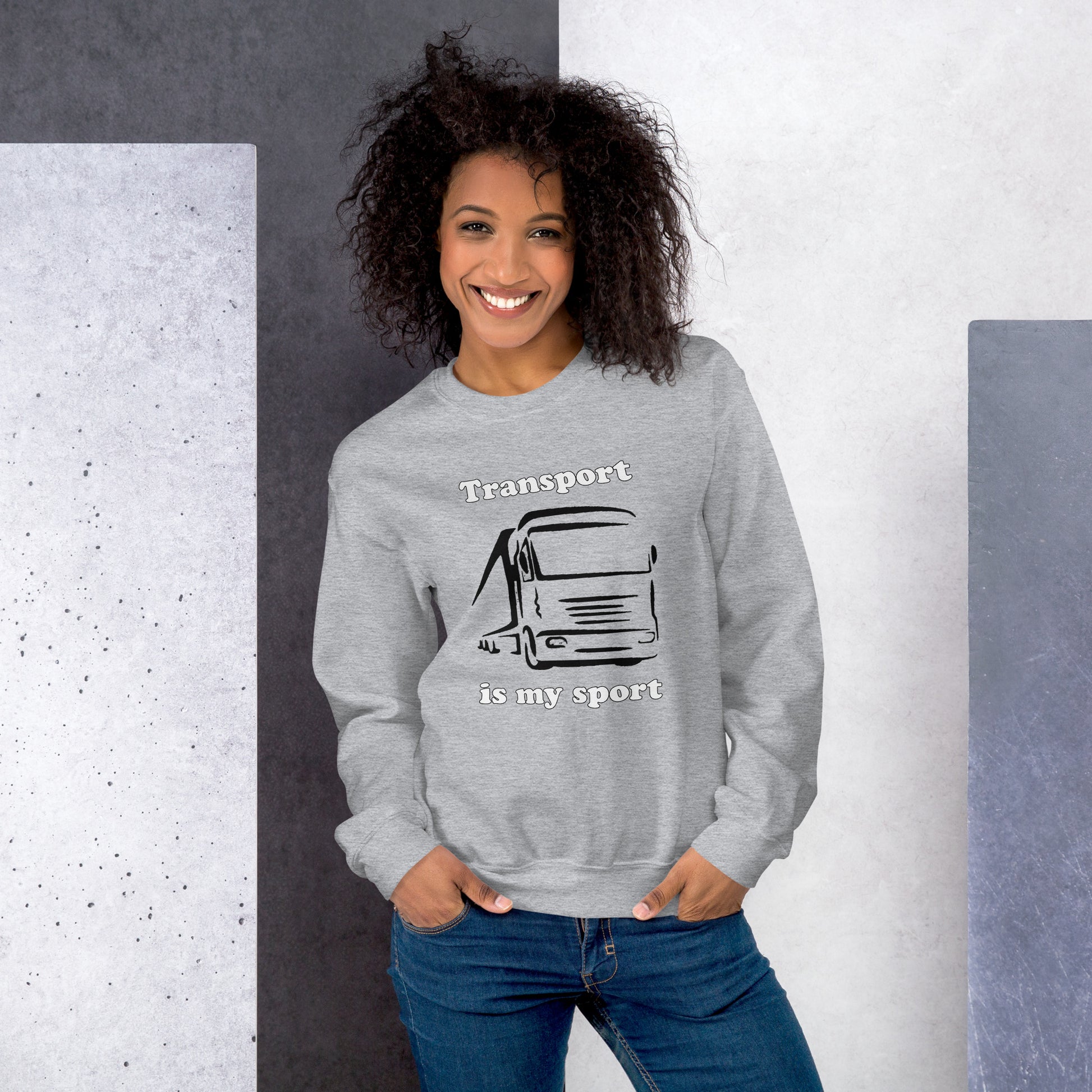 Woman with grey sweatshirt with picture of truck and text "Transport is my sport"