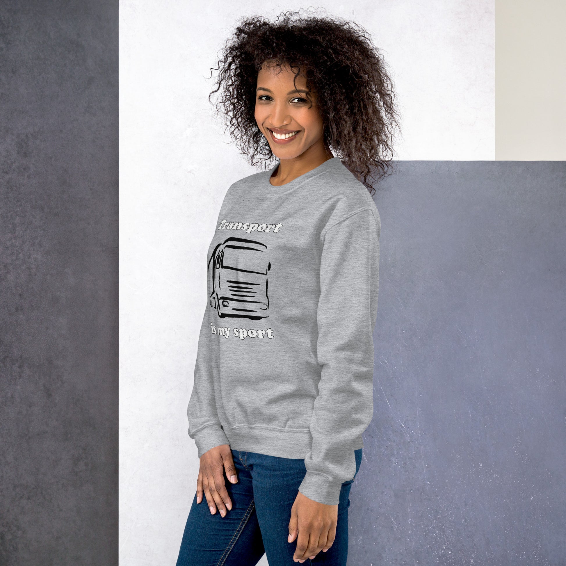 Woman with grey sweatshirt with picture of truck and text "Transport is my sport"