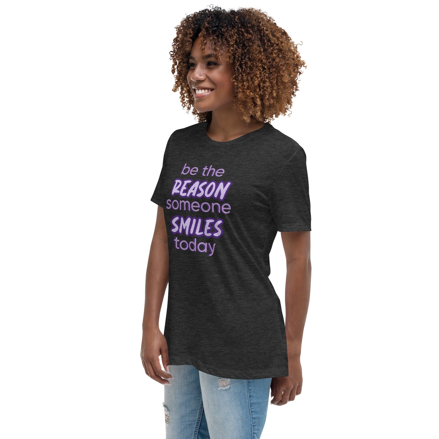 Woman with dark grey T-shirt and the quote "be the reason someone smiles today" in purple on it. 