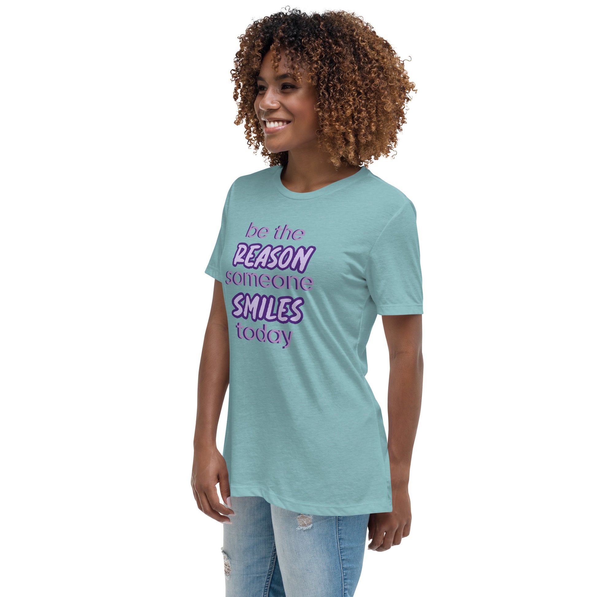 Woman with blue lagoon T-shirt and the quote "be the reason someone smiles today" in purple on it. 