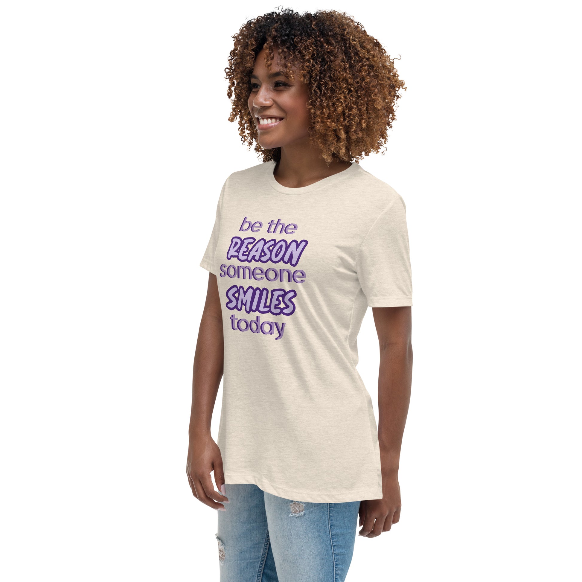 Woman with naturel T-shirt and the quote "be the reason someone smiles today" in purple on it. 