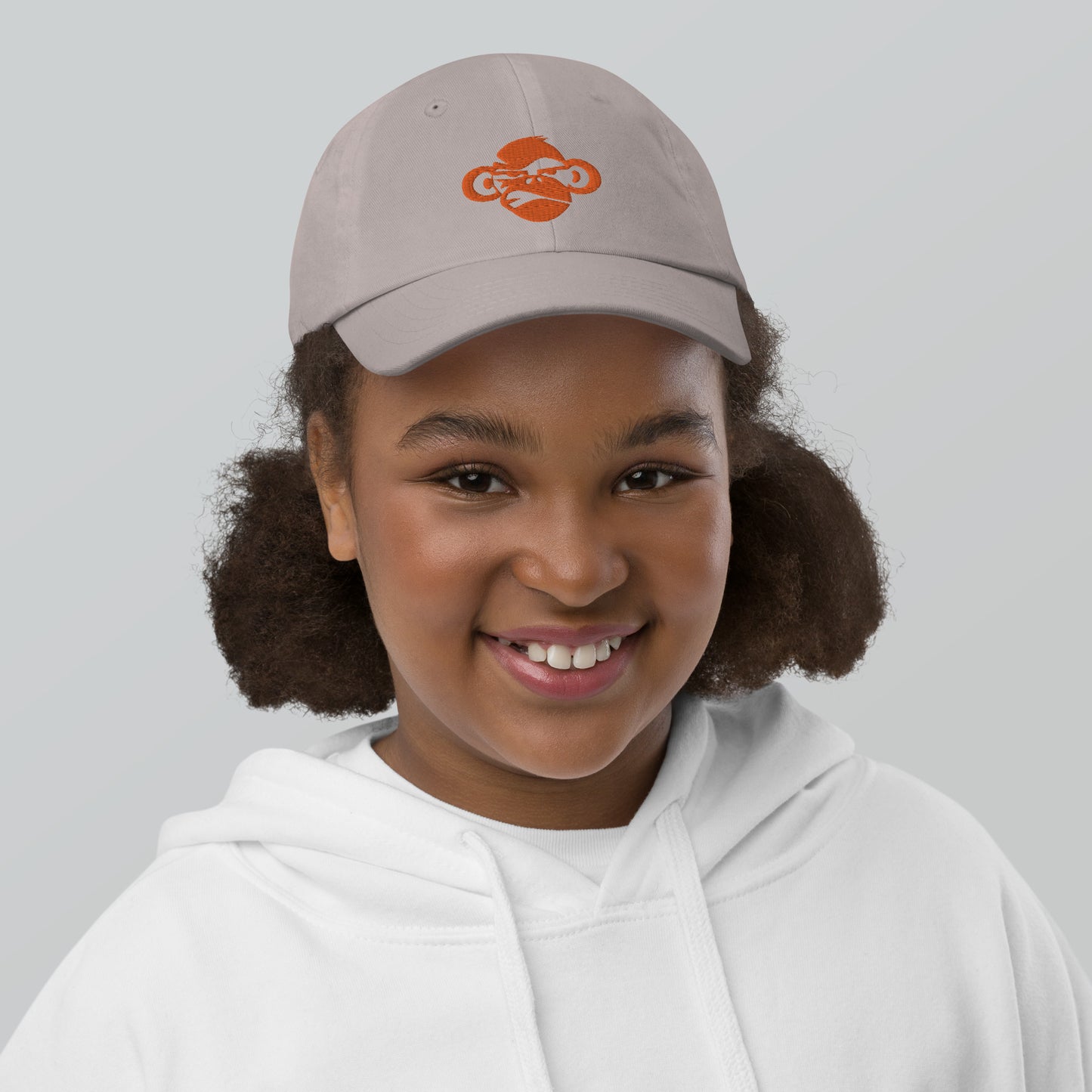 Youth with grey baseball cap with a print of a head of a monkey in color brown