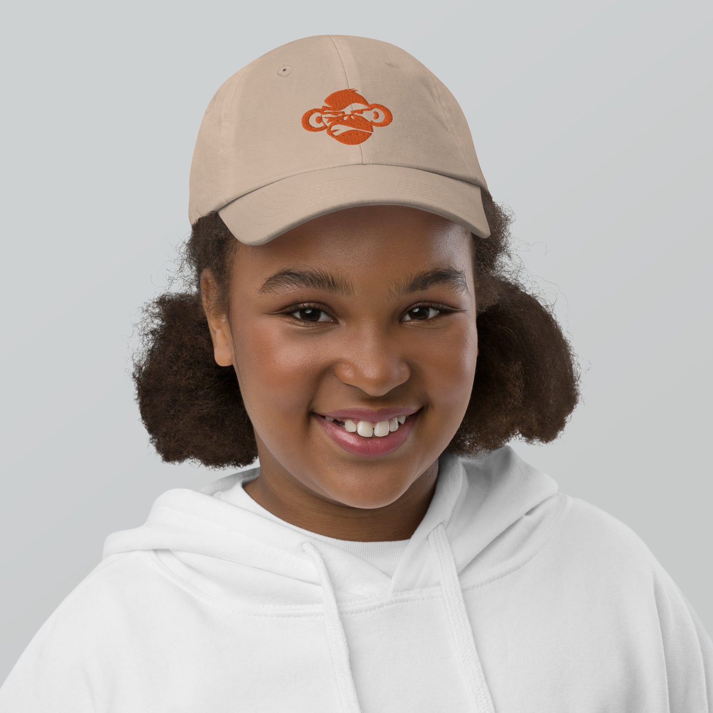 Youth with khaki baseball cap with a print of a head of a monkey in color brown