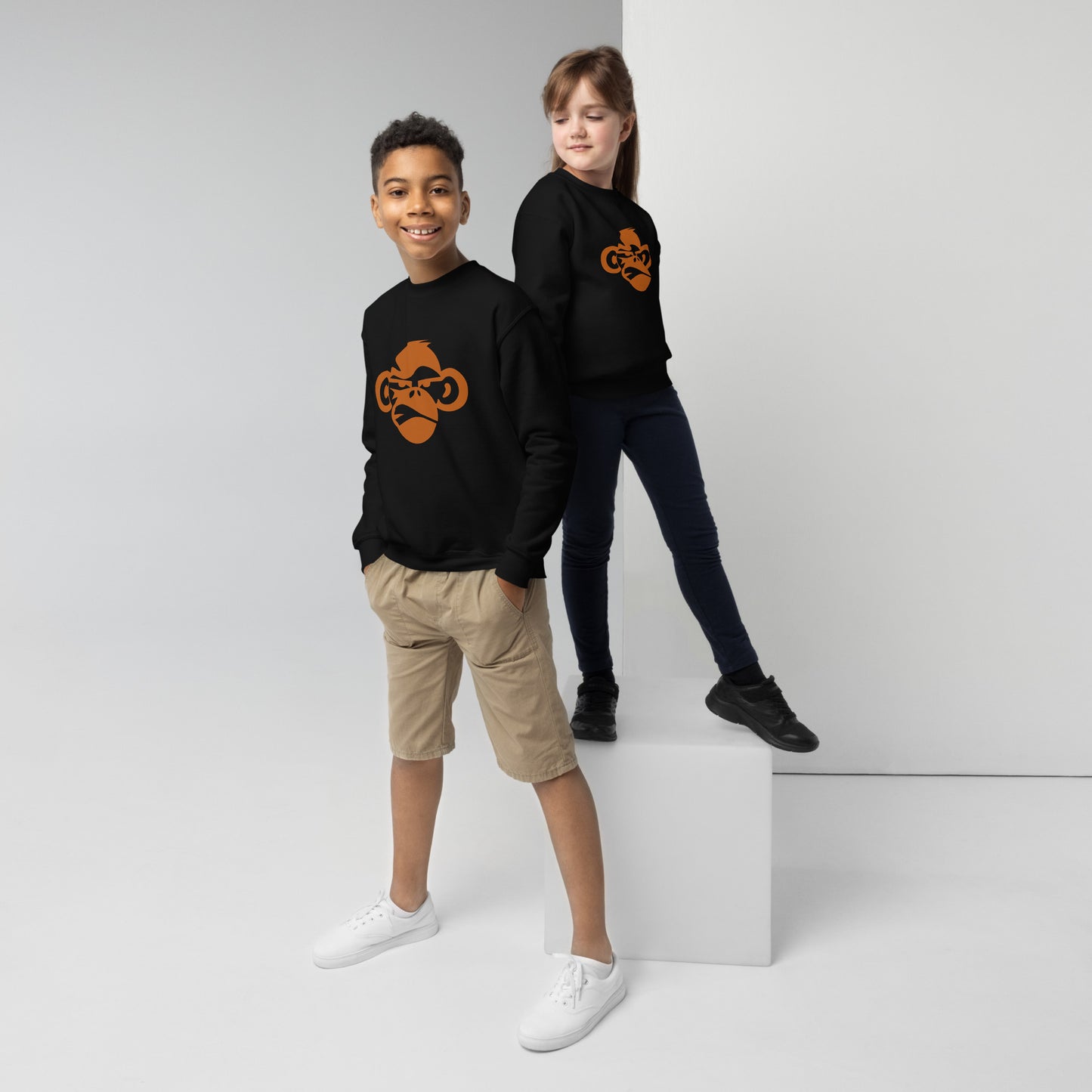 Youth with black sweatshirt with a print of a head of a monkey in color brown